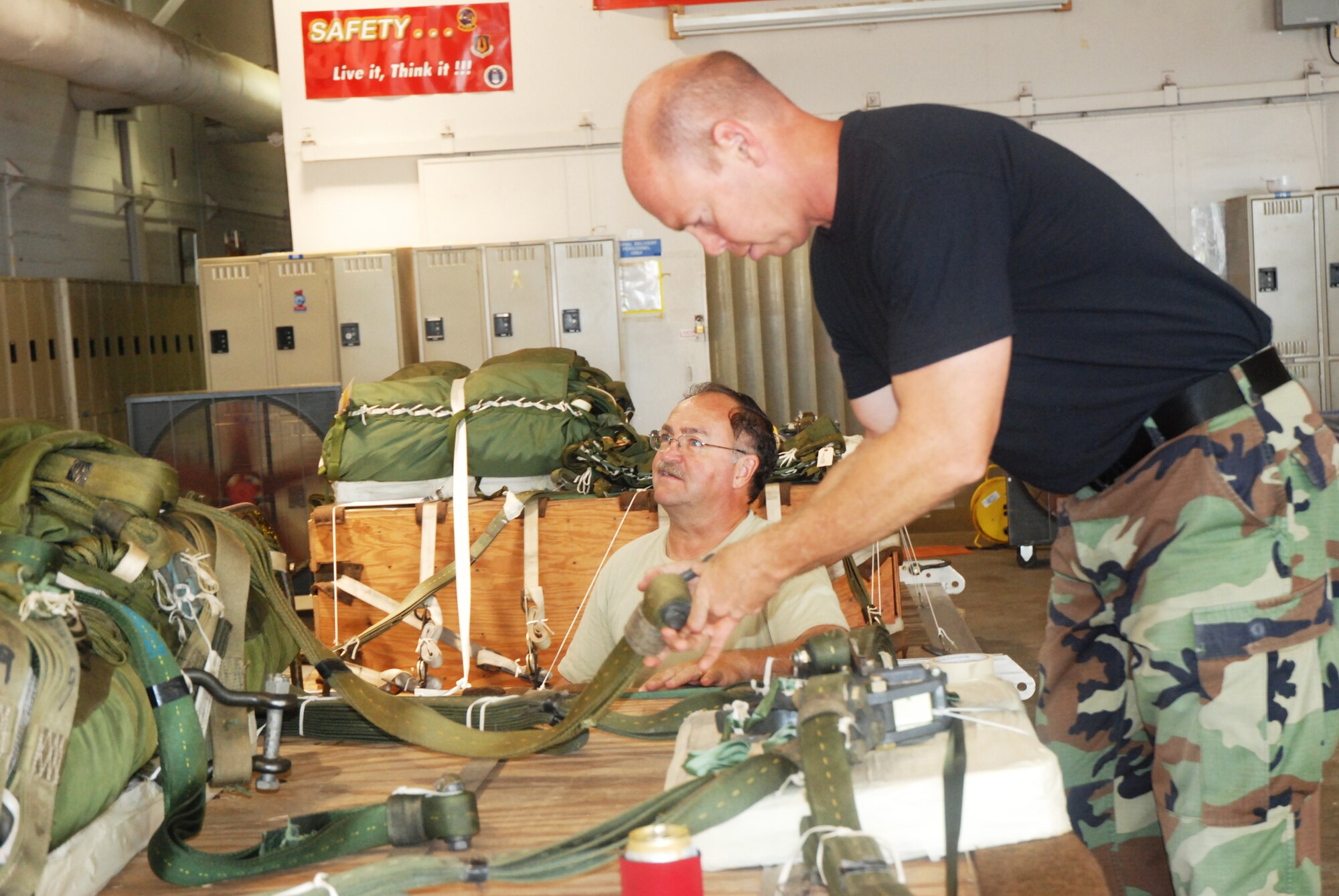 Tech. Sgt. Johhny Cooper lends a helping hand to Staff Sgt. Dallas Criswell in assembling a "heavy," which is a load of materials that will be dropped out of a C-130 Aircraft. The Airmen are members of the 94th Aerial Delivery Flight. (U.S. Air Force photo/Kennith Green)