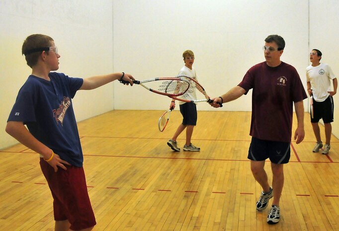 J.R. Nobel and Andrew Fields, 14, tap racquets after winning a round of racquetball at the Fitness and Sports Center here Aug. 14. The fitness center features two racquetball courts and offers all the equipment needed to play for free, which includes racquets, racquetballs and eye protection. Nobel is a retired master sergeant and Fields is the son of Master Sgt. Leland Fields, a loadmaster superintendent with the 437th Operations Group. (U.S. Air Force photo/Staff Sgt. Daniel Bowles)