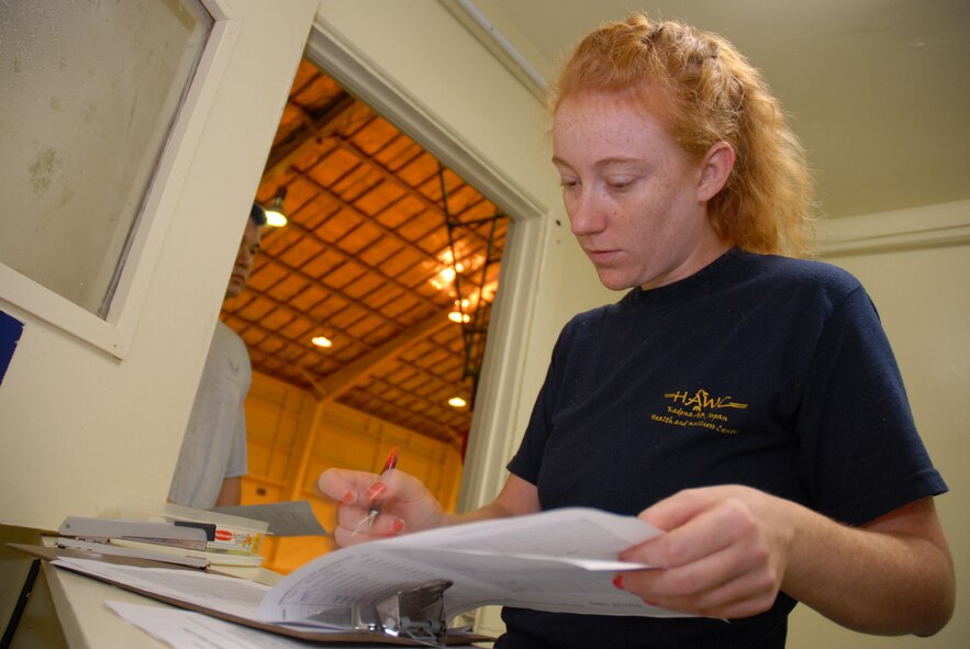 Amber Drapes, Kadena Health and Wellness Center fitness testing specialist, prepares paperwork for Airmen preparing to take their Performance Fitness Test Aug. 14.  All fitness testing at Kadena is now conducted by specialists at the HAWC to ensure standardization as part of a mandate by Gen. Carrol Chandler, Pacific Air Forces commander.  (U.S. Air Force photo/Staff Sgt. Christopher A. Marasky)