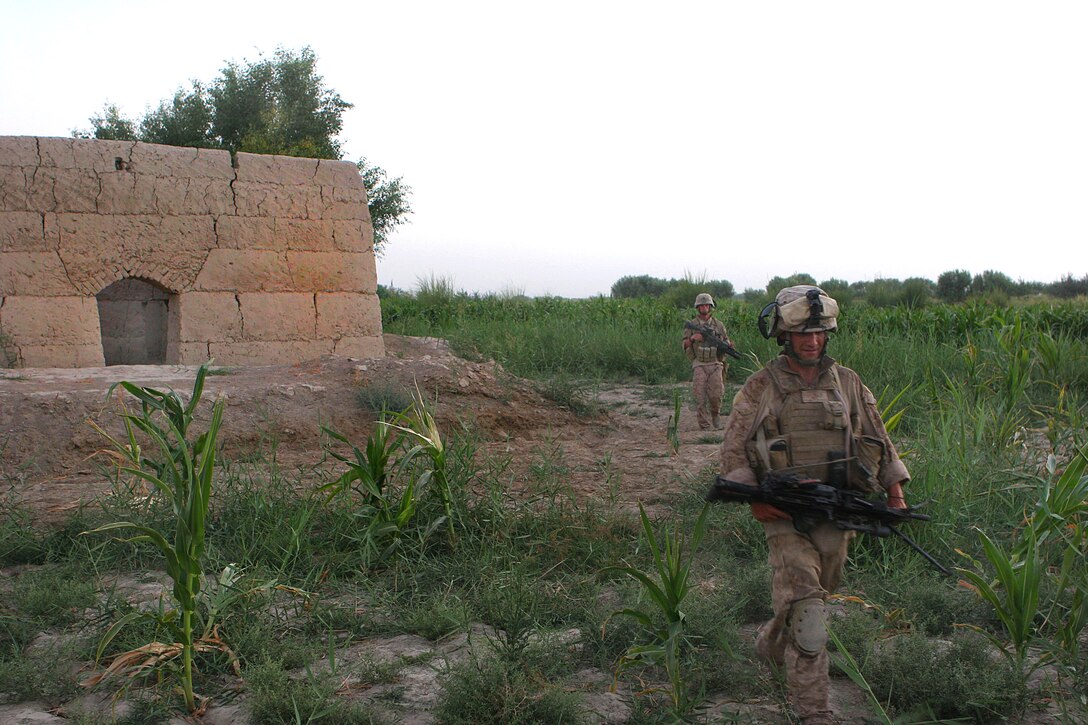 U.S. Marine Corps Pfc. Justin C. Kilgore patrols past the compound his unit held for two days during Operation Khanjar in Garmsir district in Helmand province, Afghanistan, Aug. 10, 2009. Kilgore is assigned to Echo Company, 2nd Battalion, 8th Marine Regiment.