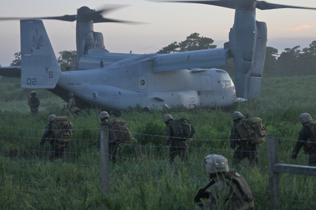Scout snipers with from Charlie Company, Battalion Landing Team 1st Battalion, 9th Marine Regiment, 24th Marine Expeditionary Unit, rally towards a MV-22 Osprey, from Marine Medium Tilt Rotor Squadron -162, 24th MEU, after completing a situational training exercise during the Heliborne Company Raid Course at Camp Lejeune, N.C. Aug. 19.  Charlie Company trained with Special Operations Training Group to become the 24th MEU’s helo raid force for its upcoming deployment.  (U.S. Marine Corps photo by Cpl. Alex C. Guerra)