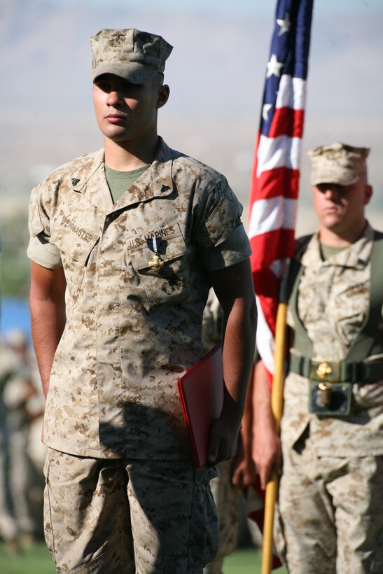 Cpl. Richard S. Weinmaster, a Squad Automatic Weapon gunner with 3rd Platoon, Company E, 2nd Battalion, 7th Marine Regiment, stands in front of the color guard after he was awarded the Navy Cross for valor and a meritorious promotion to corporal at a ceremony at Lance Cpl. Torrey L. Gray Field Aug. 20.