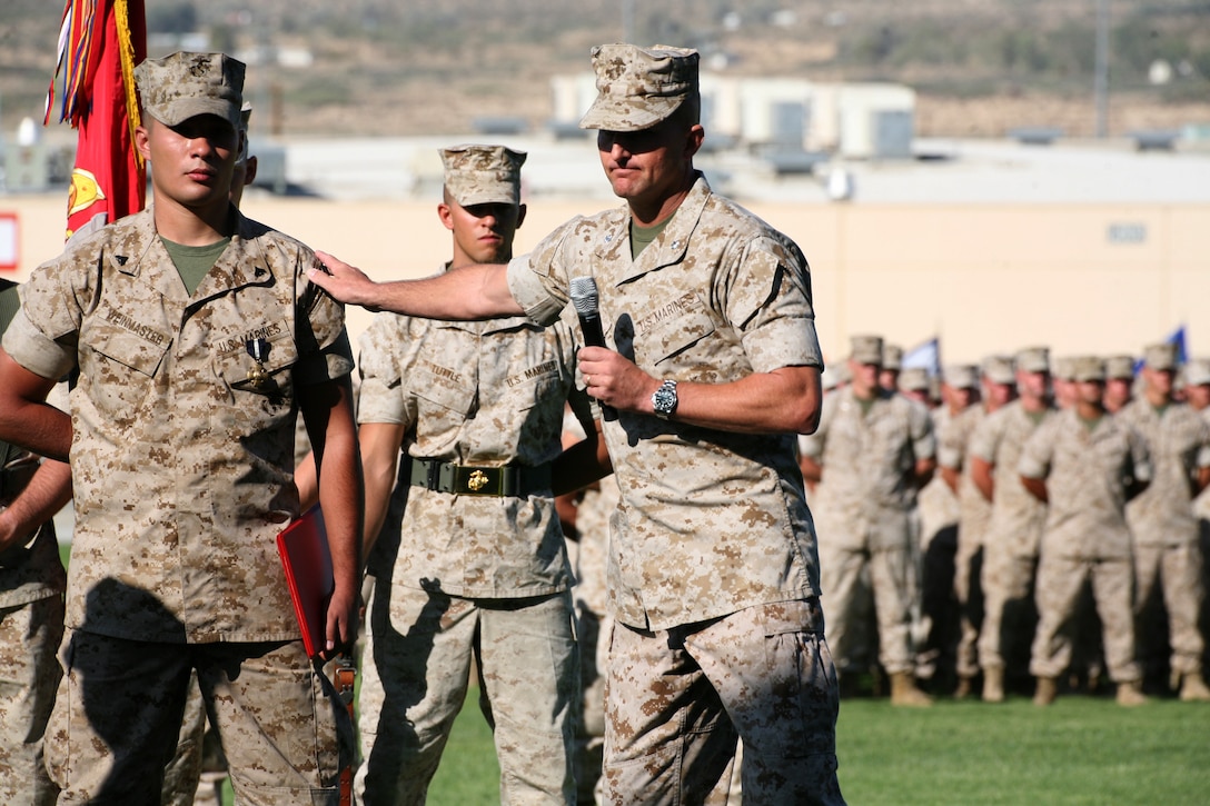 Lt. Col. John M. Reed, speaks on behalf of Cpl. Richard S. Weinmaster, a Squad Automatic Weapon gunner with 3rd Platoon, Company E, 2nd Battalion, 7th Marine Regiment, who received the Navy Cross for valor and a promotion to corporal moments before during a ceremony held Thursday at Lance Cpl. Torrey L. Gray Field.