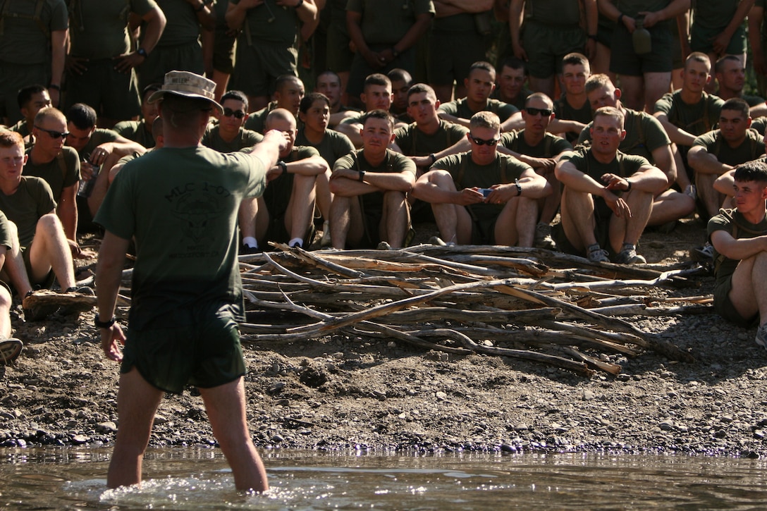 Staff Sgt. Jeremy Miller, a mountain warfare training instructor with the Unit Training Group, teaches a stream crossing class to the Marines and sailors of Company K, 3rd Battalion, 7th Marine Regiment, at the Leavitt Training Area here Aug. 20. During the class, Miller demonstrated different techniques to use when crossing rivers and streams such as using sticks to determine the depth of the water and for support.