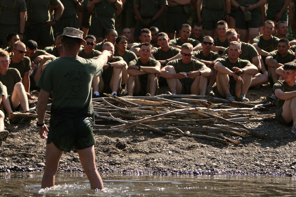 Staff Sgt. Jeremy Miller, a mountain warfare training instructor with the Unit Training Group, teaches a stream crossing class to the Marines and sailors of Company K, 3rd Battalion, 7th Marine Regiment, at the Leavitt Training Area here Aug. 20. During the class, Miller demonstrated different techniques to use when crossing rivers and streams such as using sticks to determine the depth of the water and for support.