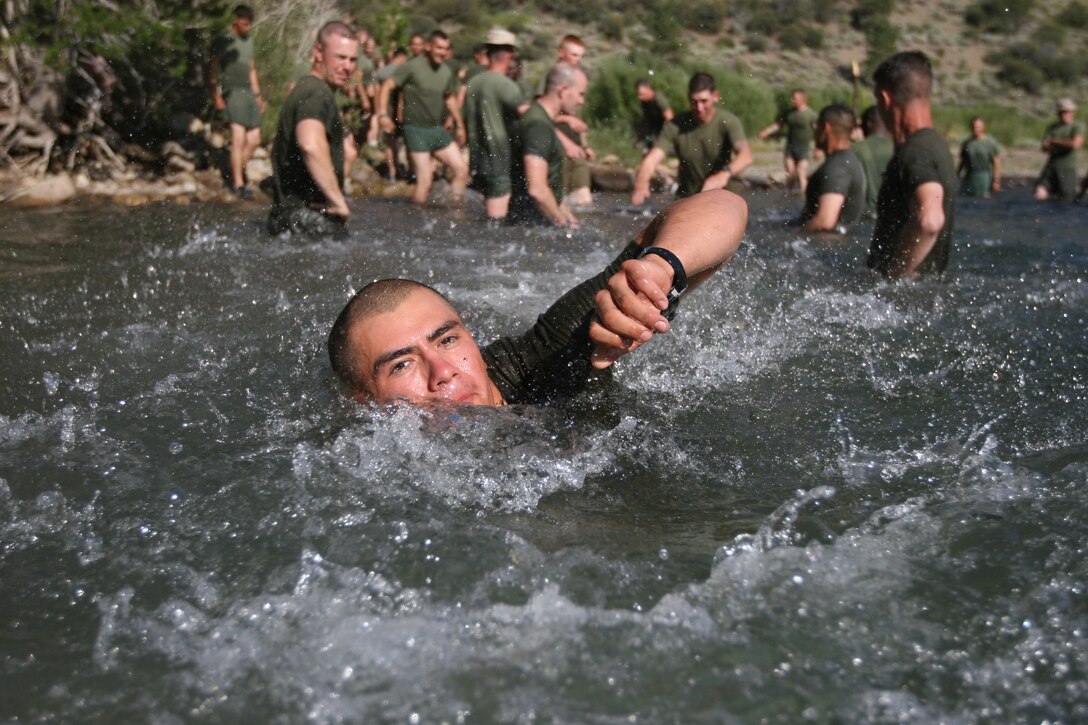 Lance Cpl. Ramirez, a rifleman with Company K, 3rd Battalion, 7th Marine Regiment, swims across a stream during a stream crossing training exercise at the Mountain Warfare Training Center’s Leavitt Training Area here Aug. 20. The exercise focused on moving fire teams across streams and rivers as safely as possible.