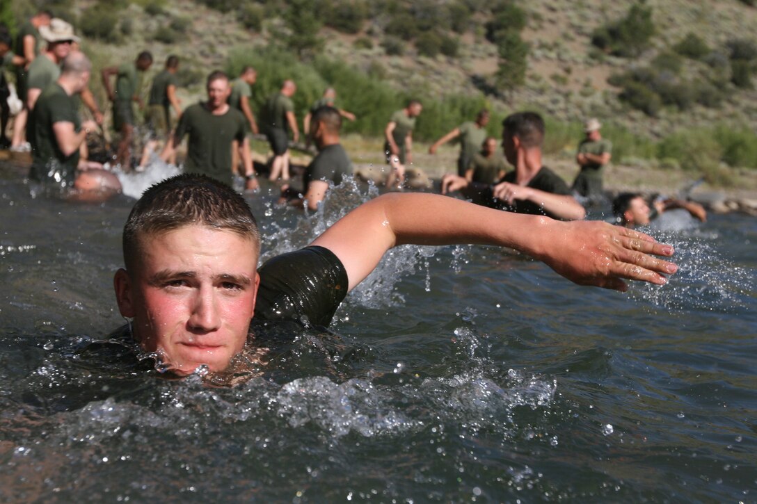Lance Cpl. Randy Devore, a rifleman with Company K, 3rd Battalion, 7th Marine Regiment, swims across a stream during a stream crossing training exercise at the Mountain Warfare Training Center’s Leavitt Training Area here Aug. 20. Devore, a Cherry Point, N.C., native, said he was glad to cool off in the water after nearly a four mile hike to the training area.