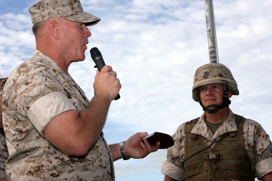 U.S. Marine Lt. Gen. Richard Zilmer, III Marine Expeditionary Force Commanding General, presents Maj. Gen. Robert Neller with a momentum during the 3D Marine Division Change of Command Ceremony, on Camp Hansen, Okinawa, Japan, Aug. 20, 2009.  A change of command ceremony is a formal change over of duties from one commanding officer to another in the presence of the unit.  (U.S. Marine Corps photo by Cpl. John A. Chretien/Not Released)