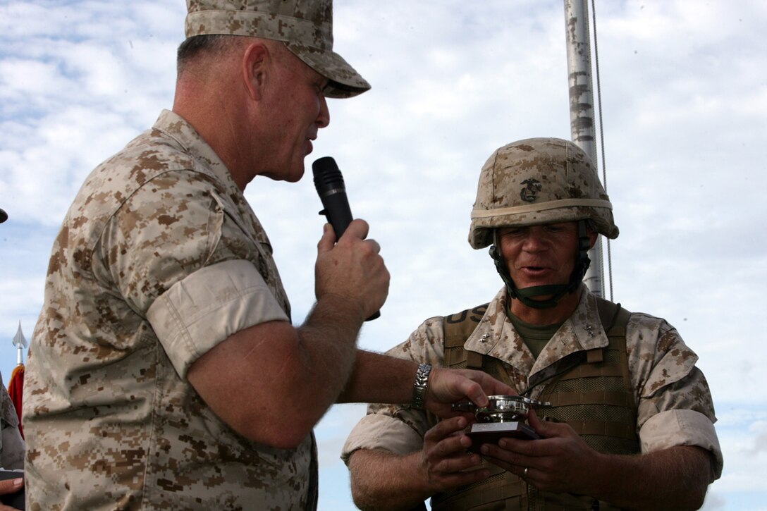 U.S. Marine Lt. Gen. Richard Zilmer, III Marine Expeditionary Force Commanding General, presents Maj. Gen. Robert Neller with a momentum during the 3D Marine Division Change of Command Ceremony, on Camp Hansen, Okinawa, Japan, Aug. 20, 2009.  A change of command ceremony is a formal change over of duties from one commanding officer to another in the presence of the unit.  (U.S. Marine Corps photo by Cpl. John A. Chretien/Not Released)