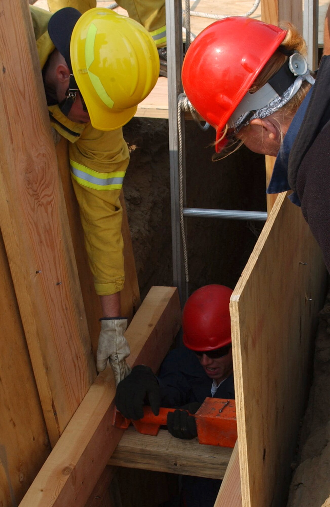 Personnel from the Travis Fire Department, prepare to install wood shoring during a trench rescue training exercise, Aug. 11.  This training focuses on the rescuer safety, preplanning, assessing soil composition, cave-in evaluations, stabilization and shoring using wood, hydraulic and air shores. (U.S. Air Force photo/ Senior Airman Liliana Moreno)