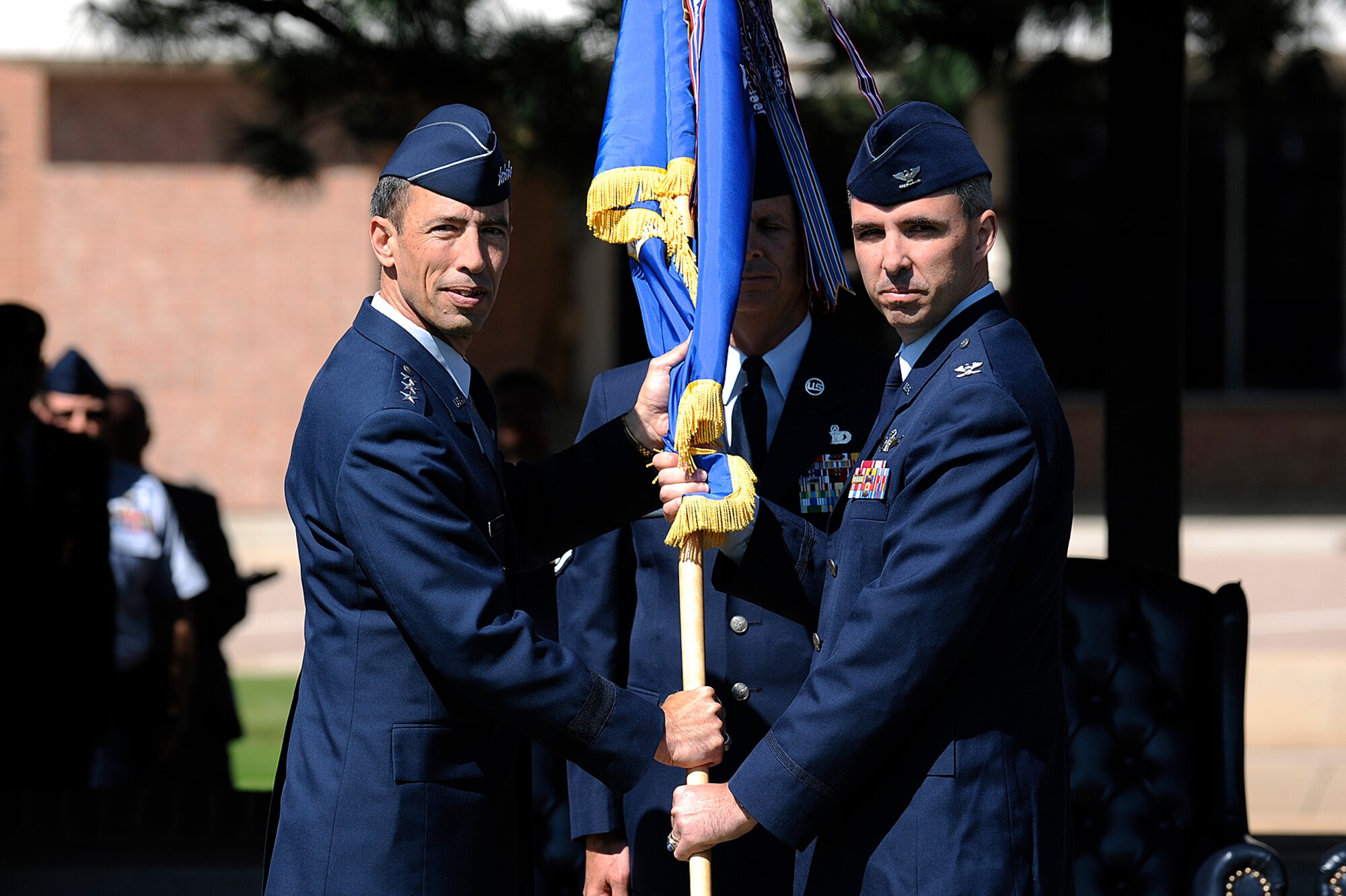 Col. Stephen Whiting (right) receives the 21st Space Wing guidon from Lt. Gen. Larry James, 14th Air Force commander, as he assumes command during the wing’s change-of-command ceremony Aug. 20 at the Peterson AFB Parade Field. As 21st SW commander, Colonel Whiting provides support and protection for more than 16,000 people who live and/or work on Peterson each day. He oversees nearly 2,000 military personnel, 3,000 civilian and contractor personnel at six military installations around the United States, along with space surveillance and missile warning units in five countries. Last year Peterson had nearly $1.2 billion in economic impact upon the local community. Colonel Whiting comes to the wing from Newport, R.I., where he was the chief of staff United States Air Force fellow with duty at the chief of Naval operations' Strategic Studies Group. He assumed command from Col. Jay Raymond who is now the director of plans, programs and analyses, at Headquarters Air Force Space Command. (U.S. Air Force photo by Craig Denton)