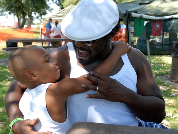 Army veteran Stephenson Harris gives his grandson a hug after the boy had his hair cut at the Yuba-Sutter Veteran's Stand Down in Marysville Aug. 20. Mr. Harris, a long time Sacramento-area resident served as a tank mechanic from 1989-1992 and has been attended the stand down in previous years. (Photo by Staff Sgt. Sarah Brown)

