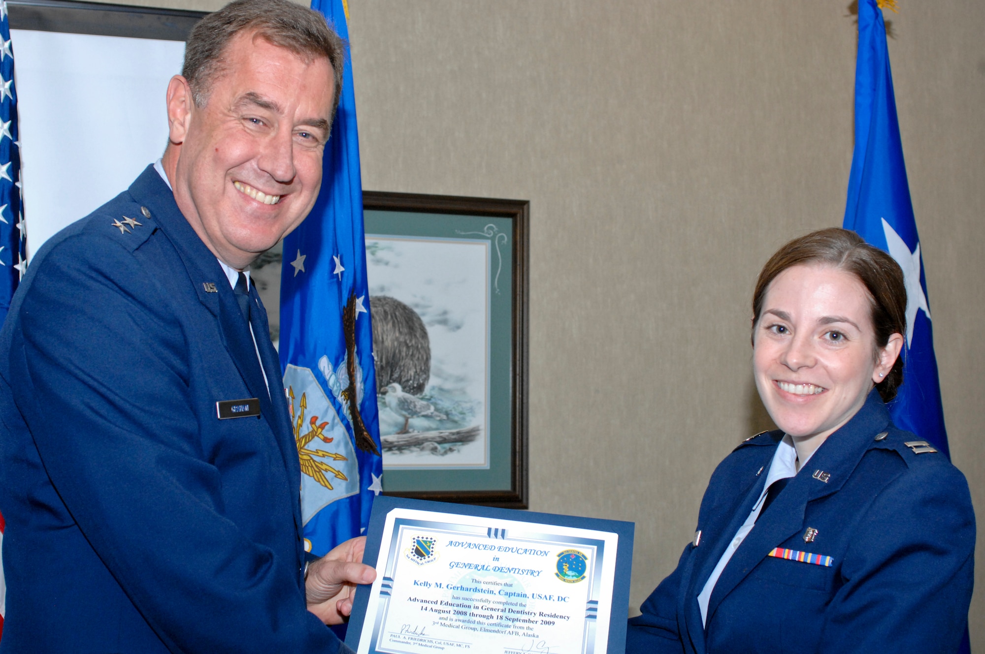 ELMENDORF AIR FORCE BASE, Alaska -- Maj. Gen. Gar Graham presents a residency graduation certificate to Capt. Kelly Gerhardstein during the ceremony at the Susitna Club Aug. 14. Gerhardstein was one of three members of the 3rd Dental Squadron to receive their certificates from the Advanced Education in General Dentistry here. The year-long program gives additional training to the new dentists so they can provide dental care without supervision. Graham is the Air Force assistant surgeon general for dental services. (U.S. Air Force photo/Airman Jack Sanders)