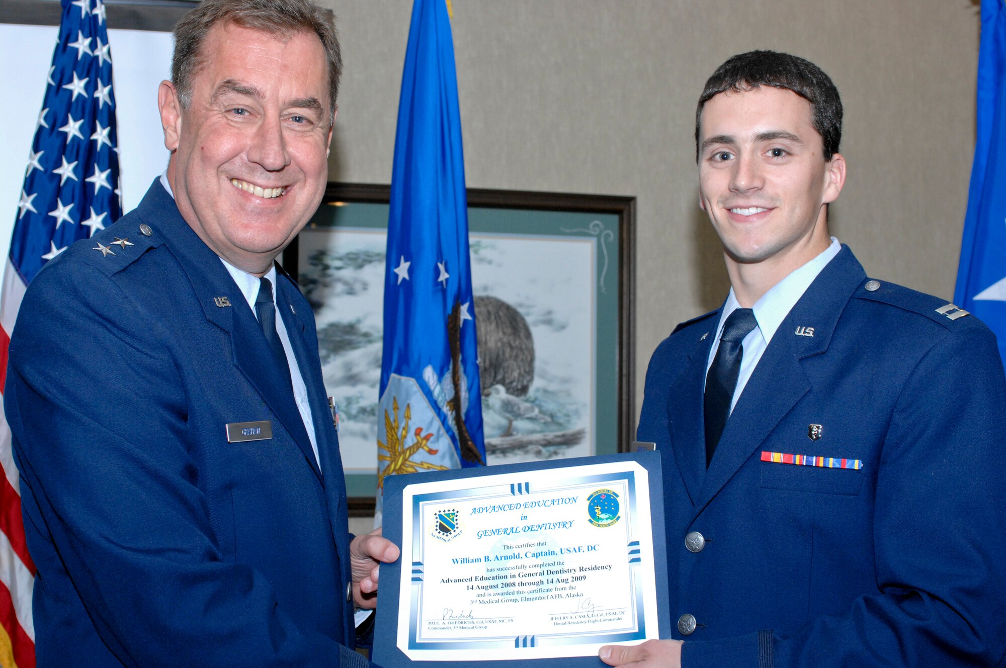 ELMENDORF AIR FORCE BASE, Alaska -- Maj. Gen. Gar Graham presents a residency graduation certificate to Capt. William Arnold during the ceremony at the Susitna Club Aug. 14. Arnold was one of three members of the 3rd Dental Squadron to receive their certificates from the Advanced Education in General Dentistry here. The year-long program gives additional training to the new dentists so they can provide dental care without supervision. Graham is the Air Force assistant surgeon general for dental services. (U.S. Air Force photo/Airman Jack Sanders)