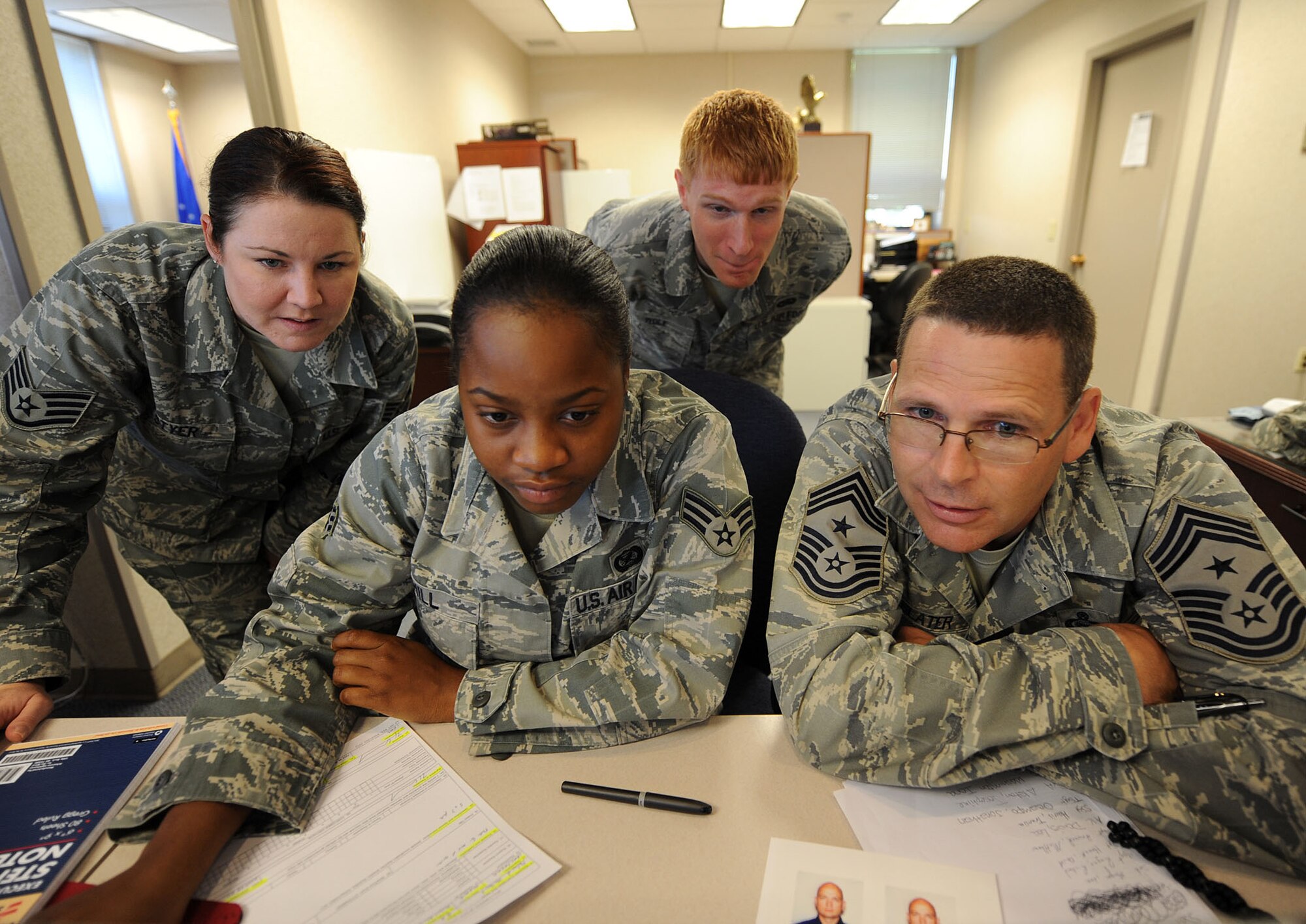 LANGLEY AIR FORCE BASE, Va. -- Chief Master Sgt. Kevin Slater, 1st Fighter Wing command chief, waits with Staff Sgt. Christina Styer, Senior Airmen Dana Hill and Zachary Wolf, 1st FW Public Affairs photographers, for staff sergeant promotion results to be released during his tour here Aug. 20.  Chief Slater learned basic tasks performed by photographers, broadcasters, and journalists during his tour of PA. (U.S. Air Force photo/Airman Rebecca Montez)