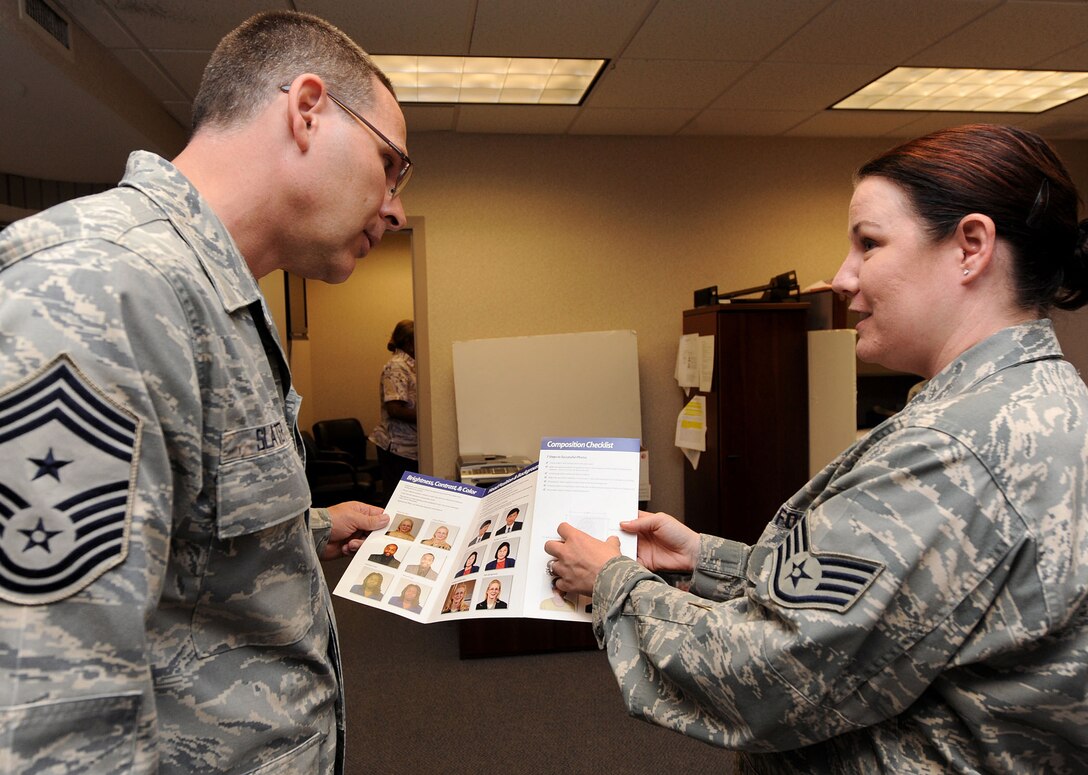 LANGLEY AIR FORCE BASE, Va. -- Chief Master Sgt. Kevin Slater, 1st Fighter Wing command chief, learns passport photo requirements from Staff Sgt. Christina Styer, 1st FW Public Affairs photographer, during his tour here Aug. 20.  Chief Slater learned basic tasks performed by photographers, broadcasters, and journalists during his tour of PA. (U.S. Air Force photo/Airman Rebecca Montez)