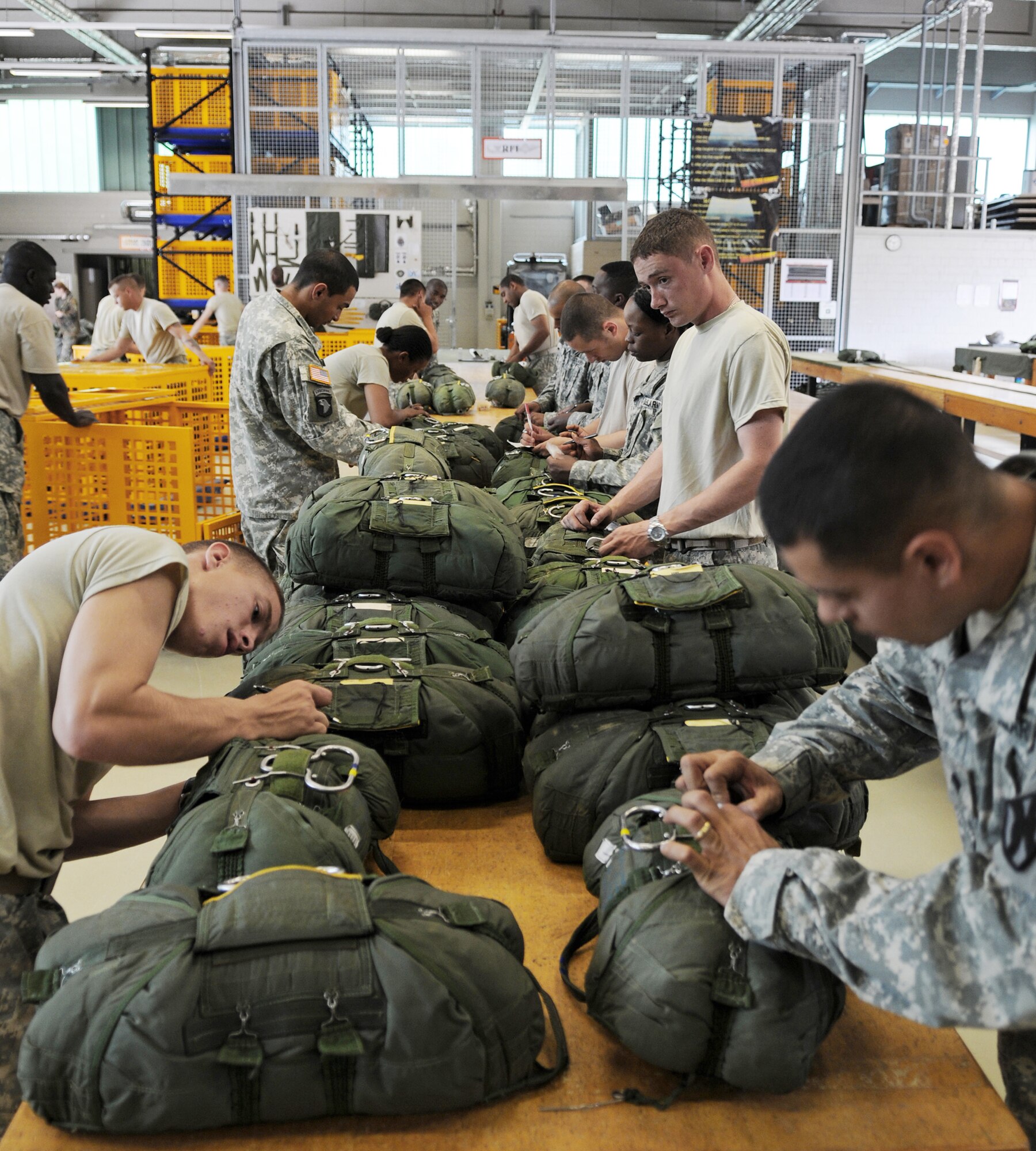 Army Pvt. Chayenne Kodiak (left) and Army Spc. Eric Meneses rig parachutes for future use Aug. 13 at Rhine Ordnance Barracks, Germany. U.S. Soldiers and Airmen performed a combined airborne jump with four other NATO countries during International Jump Week. (U.S. Air Force photo/Airman 1st Class Grovert Fuentes-Contreras) 