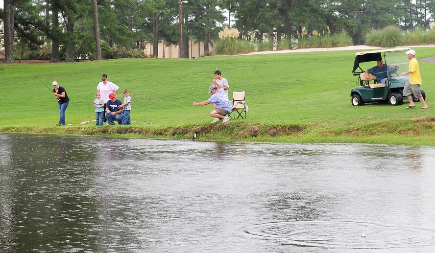 Families from Seymour Johnson Air Force Base, N.C. gather around the Three Eagles Golf Course lake to participate in a fishing derby Aug. 16, 2009. E-Z Bait and Tackle provided fishing poles and bait for families to teach children the joy of fishing. (U.S. Air Force photo by Airman 1st Class Rae Perry)