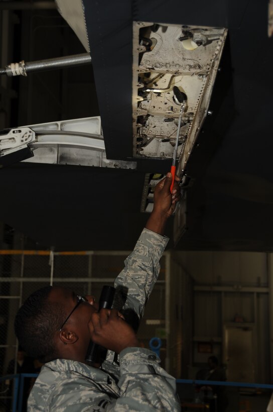 Airman 1st Class Lloyd Brown, 28th Maintenance Squadron crew chief, inspects the B-1B Lancer's swing down to ensure all lines are connected properly here, August 19.  Airman Brown uses an extendable mirror to check hard-to-see areas. (U.S. Air Force photo/Airman 1st Class Anthony Sanchelli)