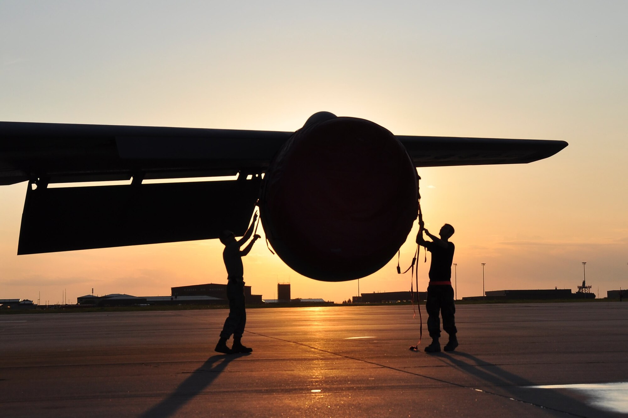 Aircraft Maintenance Airmen fasten an intake cover to the jet engine of a KC-135 Stratotanker at McConnell Air Force Base, Kan. An Air Force Reserve aircrew from the 931st Air Refueling Squadron had just returned the aircraft to the base on a July 2009 evening. Airmen from the 22nd Air Refueling Wing, the 931st's active-duty host unit, received and maintained the returning tanker. (Courtesy photo/Lt. Col. Tsuyoshi Tung)