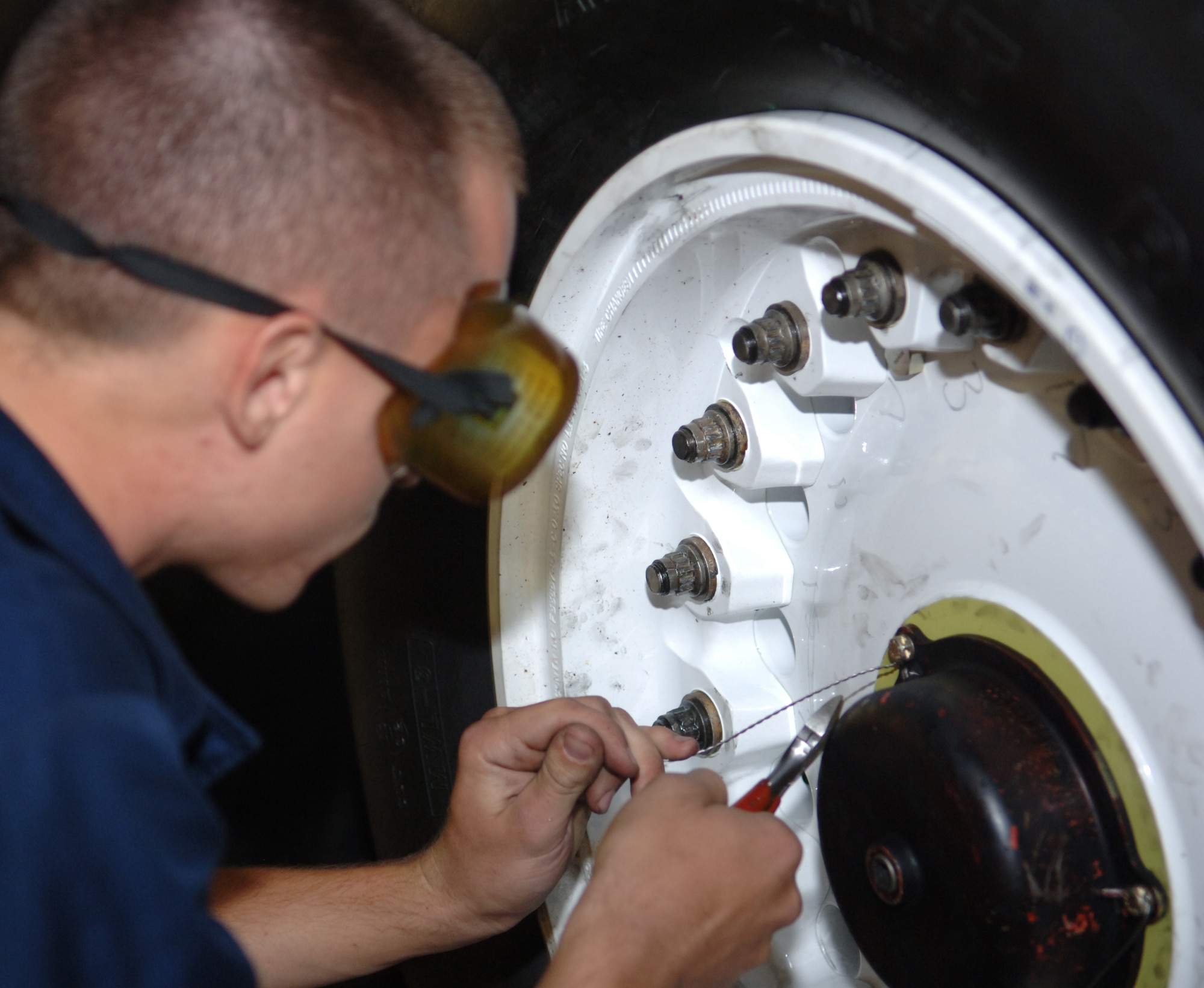 Senior Airman Brian Decker, 34th Maintenance Unit crew chief, attaches safety wire to a bolt on the B-1B Lancer's wheel here, August 19. The wire keeps the bolt from moving when the B-1 is in flight. (U.S. Air Force photo/ Airman 1st Class Jarad A. Denton)
