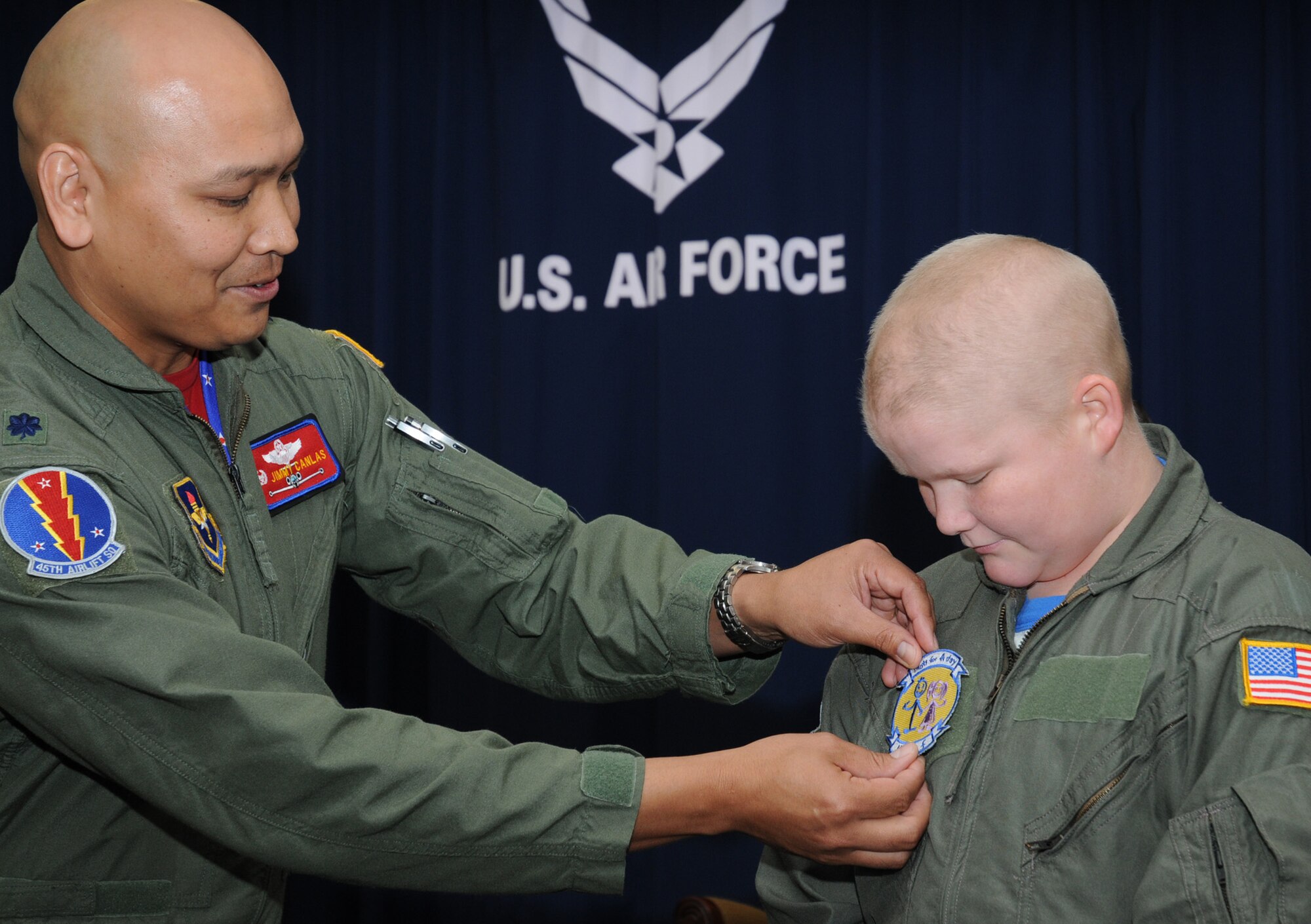 Colonel Canlas pins Sean’s “Pilot for a Day” patch on his custom-made flight suit.  (U.S. Air Force photo by Kemberly Groue)