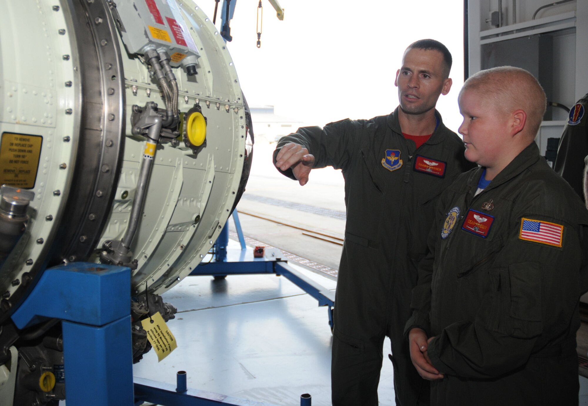 Capt. Shawn Mosher, 45th AS, shows Sean a C-21 jet engine.  He and Capt. Brett Ellis were Sean’s escorts for the day.  (U.S. Air Force photo by Kemberly Groue)