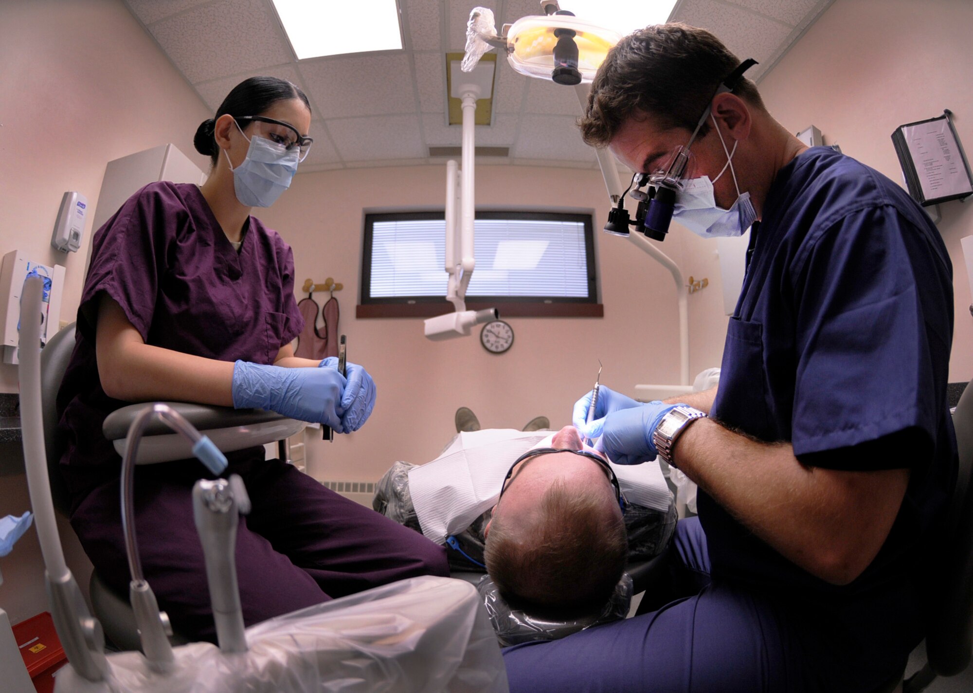 Senior Airman Kristina Lopez assists Capt. Chris Gerwig during a routine dental procedure Aug. 19, 2009, Eielson Air Force Base, Alaska. The 354th Dental Clinic provides a variety of general dentistry procedures for Airmen.  Airman Lopez is a dental technician and Captain Gerwig is a dentist assigned to the 354th Medical Group. (U.S. Air Force photo/Airman 1st Class Laura Goodgame)