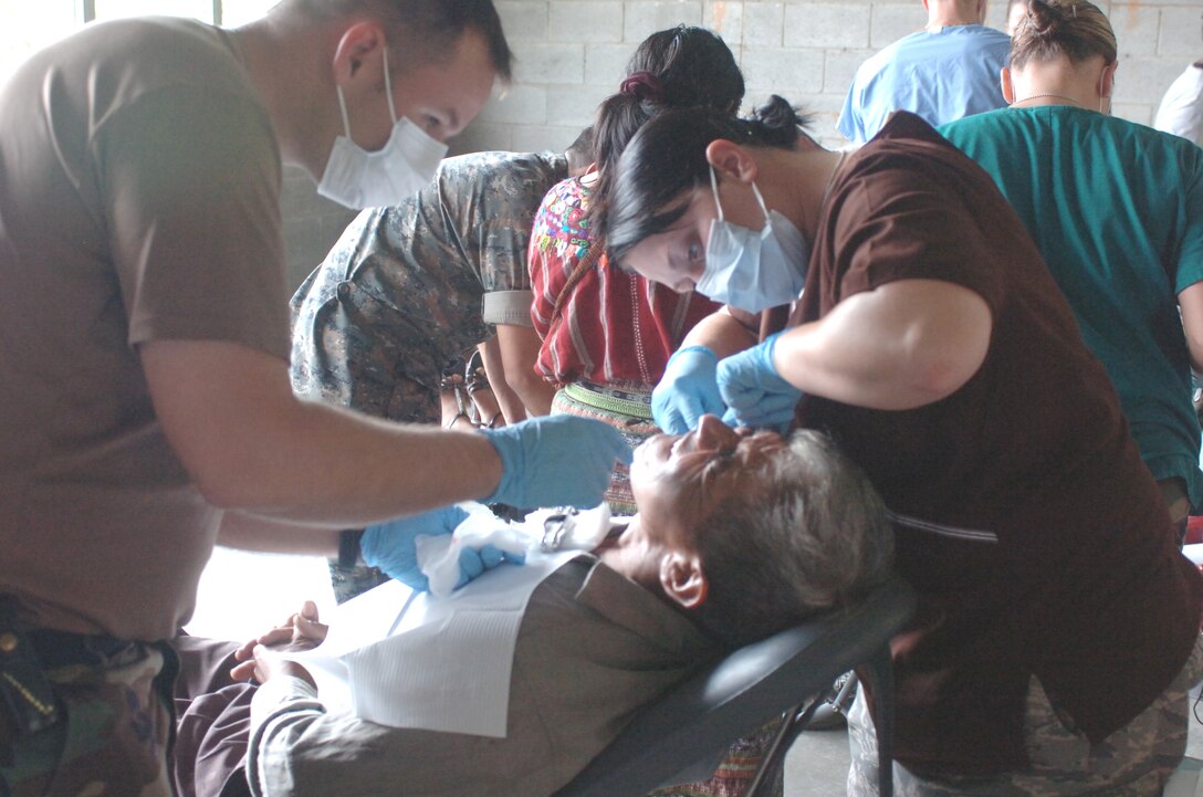Dental care – Staff Sgt. Amber Burton (right) and Technical Sgt. Scott McKenna (left) members of the Medical Group of the 188th Fighter Wing of the Arkansas Air National Guard, prepare to extract a tooth from a Guatemalan man.  The Arkansas Guard is in Guatemala for their annual training conducting a medical readiness training exercise in the village of San Miguel Chicaj in concert with the Guatemalan Army. (Air Force Photo by Maj. Keith Moore, Joint Force Headquarters Public Affairs, Arkansas Air National Guard.)
