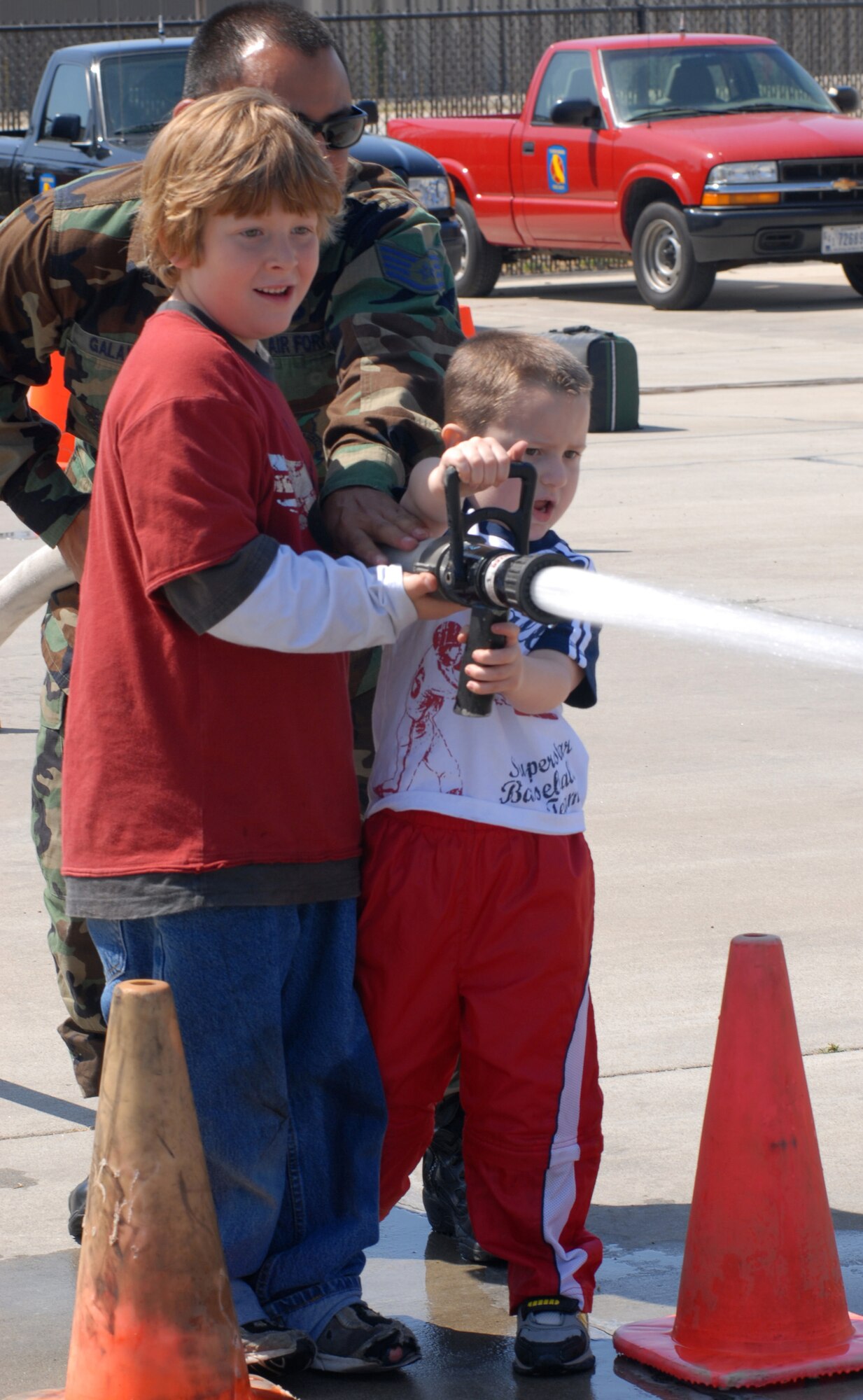 VANDENBERG AIR FORCE BASE, Calif. -- Firefighters for a day, Roman Wankowski, who is the son of Capt. Timothy Wankowski of the 30th Security Forces Squadron, and Evan McMillan, who is the son of Master Sgt. John McMillin of the 614th Air and Space Operations Center, practice their aim with a fire hose at the Kids’ Fire Camp on Aug. 15 at Fire Station 2 here. The day-long camp culminated with an obstacle course that gave the children a chance to use firefighter tools. (U.S. Air Force photo/Airman 1st Class Kerelin Molina)