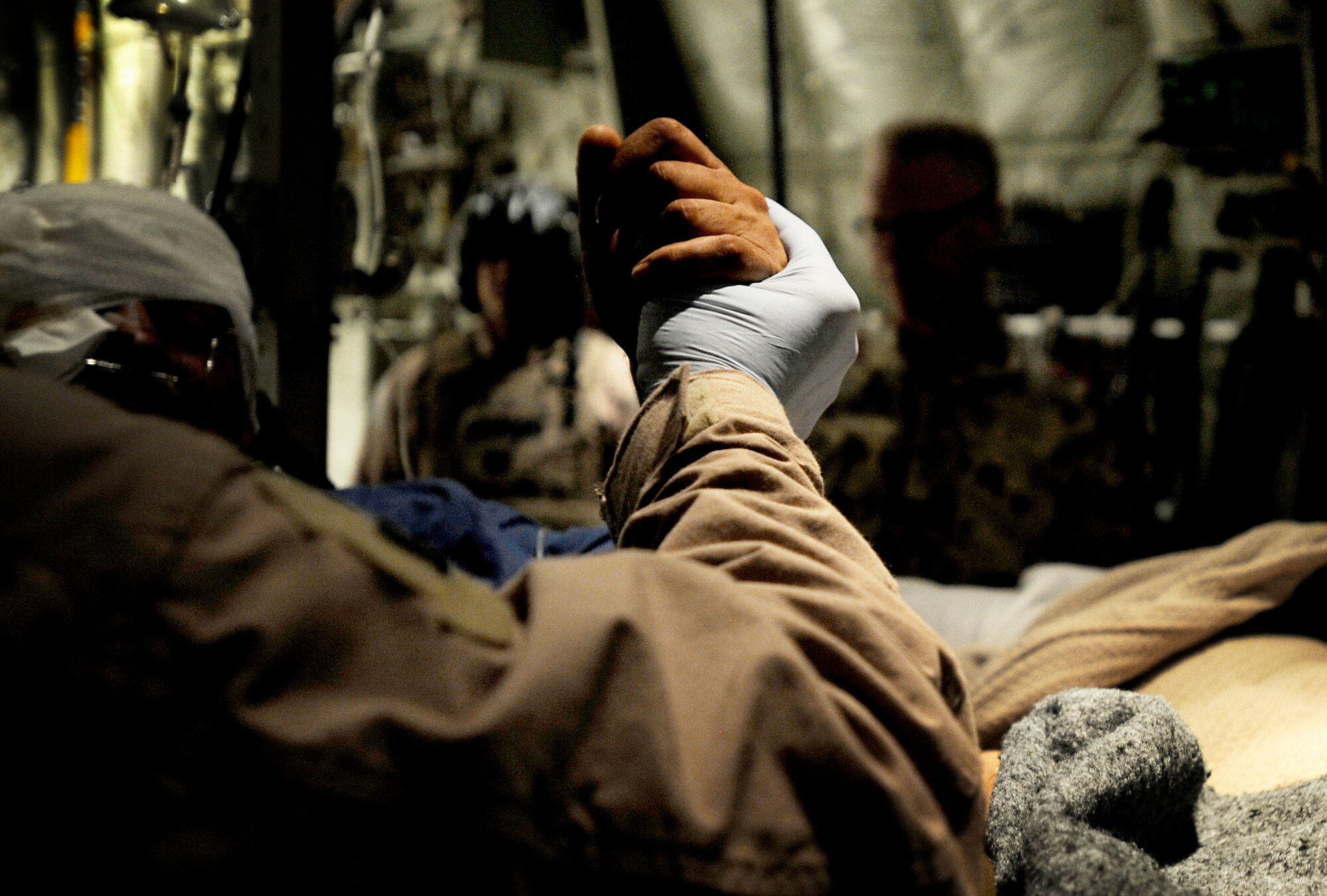 An Airman from the 451st Expeditionary Aeromedical Evacuation Flight holds the hand of a patient during an aeromedical evacuation mission to transport patients July 19 from Kandahar Airfield, Afghanistan, to Bagram Airfield, Afghanistan. (U.S. Air Force photo/Staff Sgt. Shawn Weismiller) 
