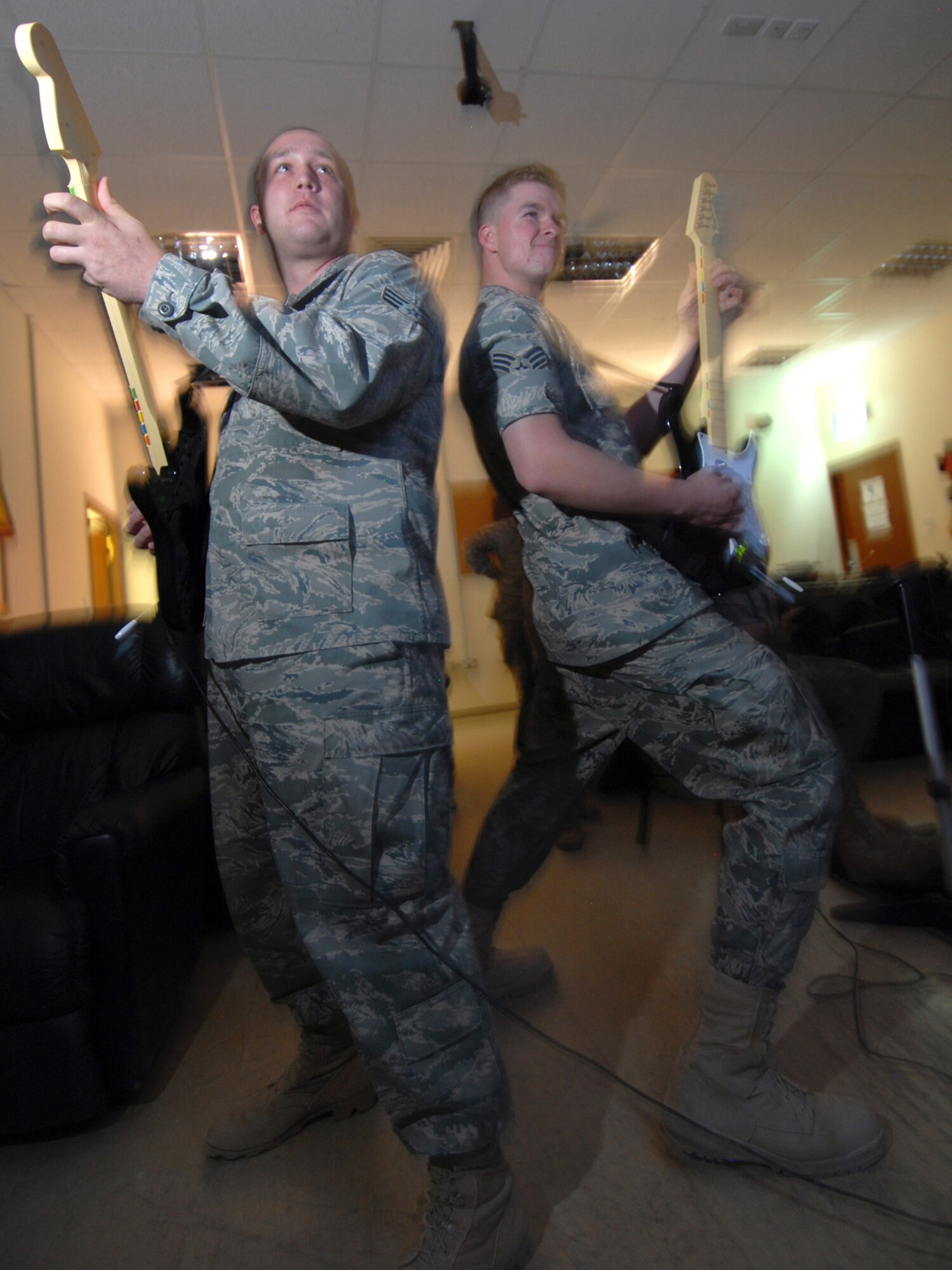 Senior Airmen Cole Owen and Casey Young, 379th Expeditionary Civil Engineer Squadron emergency management journeymen, participate in a Rock Band jam session during Wingman Week, here, Aug. 20. Airman Cole is a native of Brevard, N.C., and is deployed from Shaw Air Force Base, S.C. Airman Young hails from Rocklin, Calif. Both are deployed in support of Operations Iraqi and Enduring Freedom.  (U.S. Air Force Photo/Tech. Sgt. Jason W. Edwards)