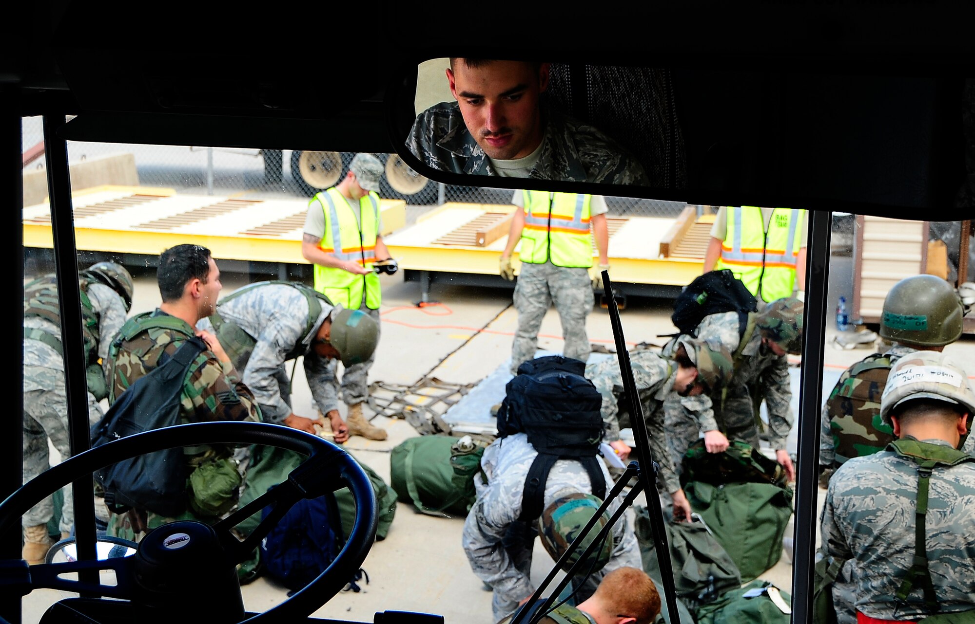 HOLLOMAN AIR FORCE BASE, N.M. -- Airmen from the 49th Aircraft Maintenance Squadron process mobility bags while Airman 1st Class Joe Gilbreath of the 49th Logistics Readiness Squadron, waits for them to load the bus here Aug. 18. (U.S. Air Force photo by Tech. Sgt. Chris Flahive)