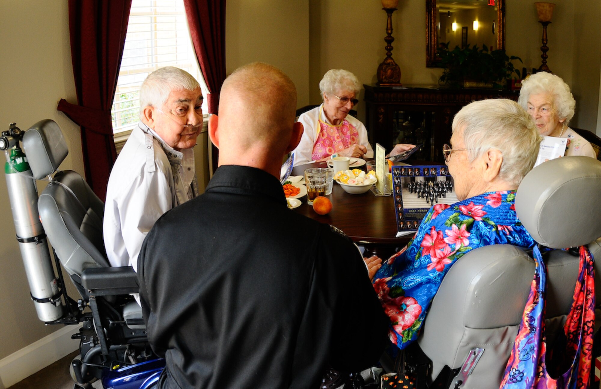 Capt. Michael Fanton, United States Air Force Honor Guard Drill Team flight commander, takes a knee and speaks with residents at the Air Force Enlisted Village. The AFEV is home to more than 200 Air Force widows. This is one of the many stops the Drill Team will make during their Florida tour this summer. (U.S. Air Force photo by Senior Airman Alexandre Montes)