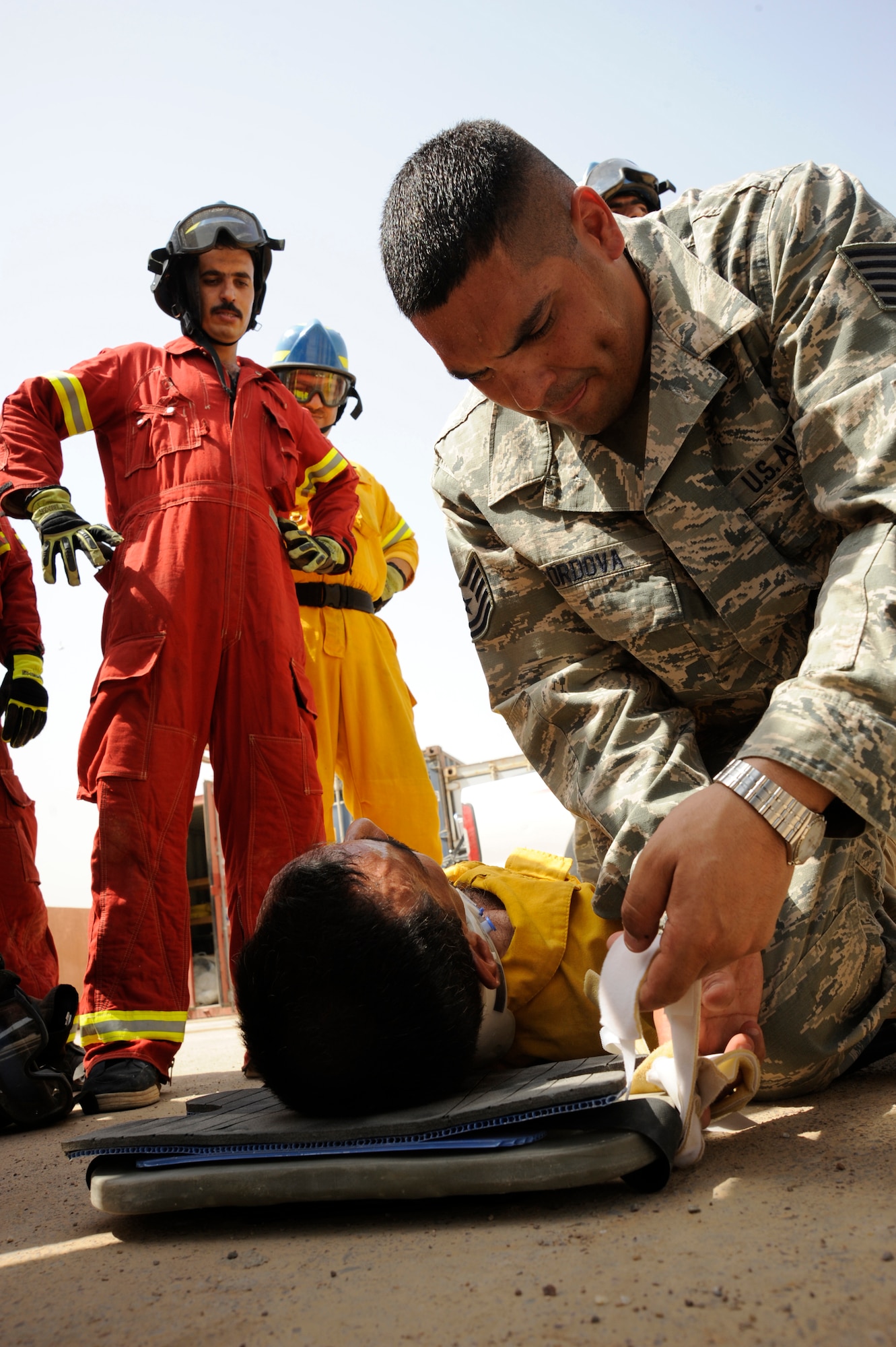 BAGHDAD, Iraq -- Air Force Tech. Sgt. Essam Cordova, 821st Expeditionary Training Squadron fire and rescue advisor, instructs Iraqi firefighter students how to properly secure a patient to a long spine board here Aug. 9, 2009. He teaches procedures in advanced rescue with auto extrication to students in the International Zone. Sergeant Cordova is deployed from Goodfellow Air Force Base, Texas, and is a native of Queens, N.Y.  (U.S. Air Force photo/Tech. Sgt. Johnny L. Saldivar/Released)