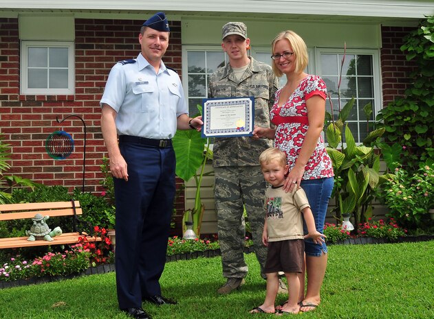 Col. John Wood presents Staff Sgt. Nicholas Burtch and Katie Burtch, joined by Thomas Burtch, 2, with a certificate for having the "Yard of the Month" in Hunley Park base housing Aug. 17. Sergeant Burtch's home was chosen abouve several others previously selected as "Yard of the Week." Colonel Wood is the 437th Airlift Wing commander. Sergeant Burtch is a storage and issue supervisor with the 437th Logistics Readiness Squadron. (Air Force Photo/Staff Sgt. Daniel Bowles)