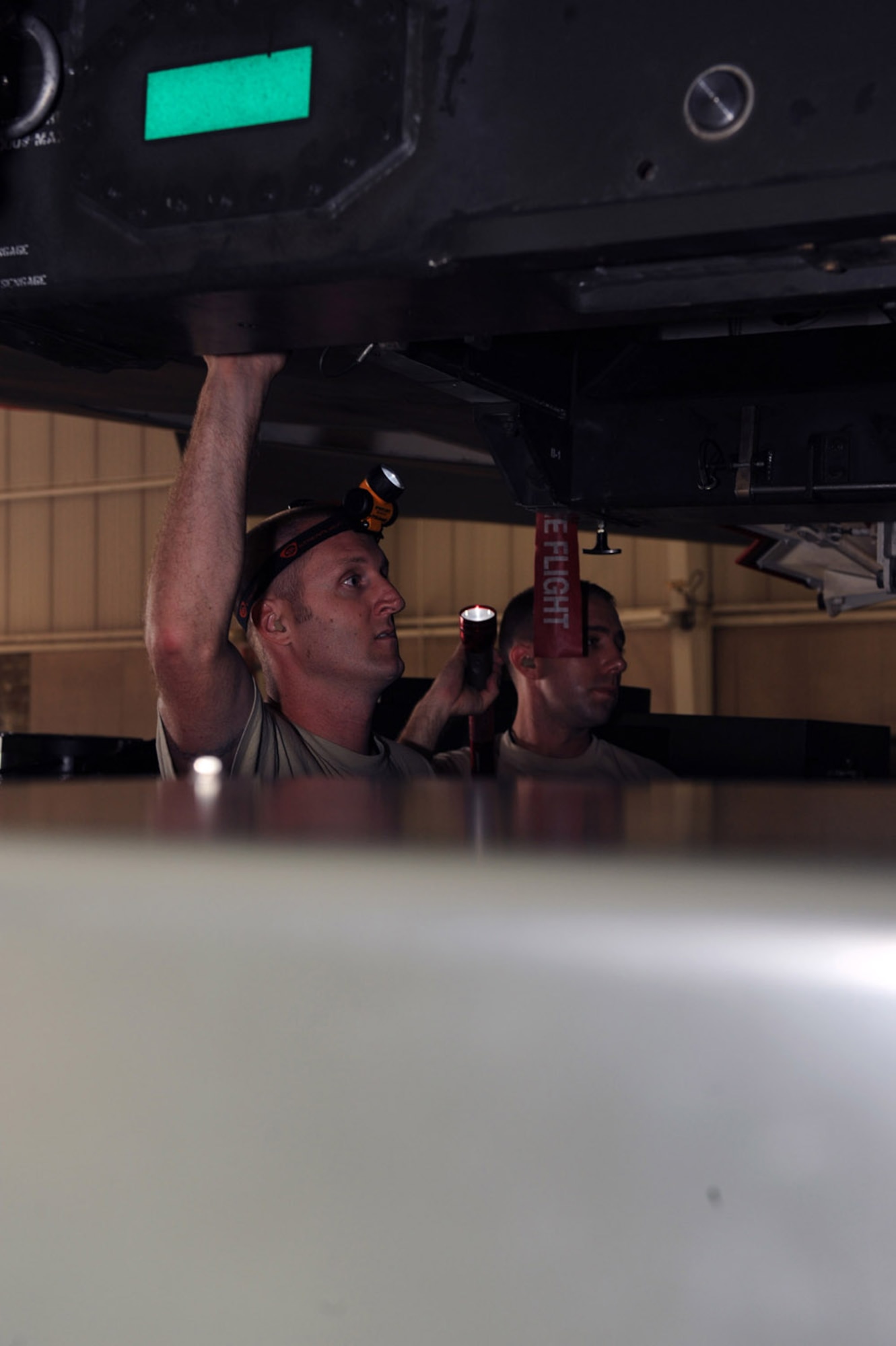 WHITEMAN AIR FORCE BASE, Mo. – Tech. Sgts. Ryan Graney (left) and Jason Lease, Loading Standardization Crew members, ensure the precise placement of a weapons trailer Aug. 14 during a download operation on the Weapons Load Trainer. The WLT here is a one-of-a-kind mock up of the B-2 that allows weapons crews to train without using a mission essential aircraft. (U.S. Air Force photo/Senior Airman Jason Huddleston)