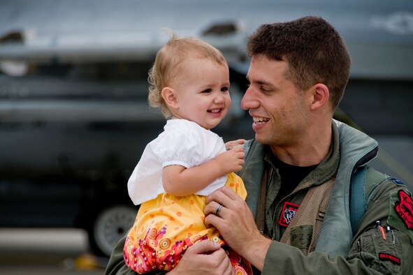 MISAWA AIR BASE, Japan -- Capt. Tyler Young, 13th Fighter Squadron pilot, shares a laugh with his daughter, Clara, after returning from Suwon Air Base, South Korea, Aug. 20. Captain Young witnessed Clara walking, something she was too young to do when he left. (U.S. Air Force photo/Senior Airman Jamal D. Sutter)