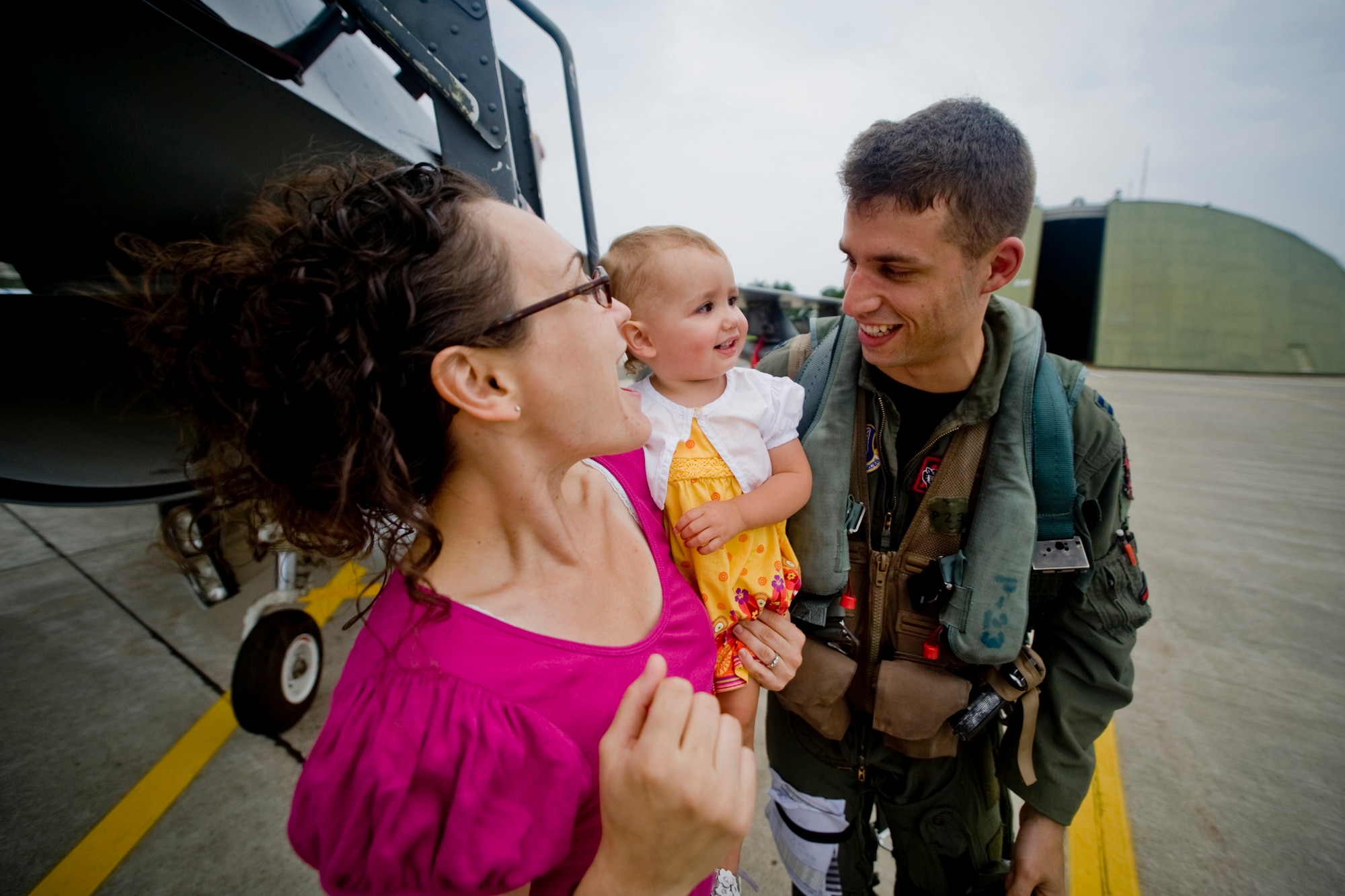 MISAWA AIR BASE, Japan -- Capt. Tyler Young, 13th Fighter Squadron pilot, shares a laugh with his wife, Anna, and daughter, Clara, after returning from a deployment Aug. 20. Captain Young was deployed to Suwon Air Base, South Korea. (U.S. Air Force photo/Senior Airman Jamal D. Sutter)