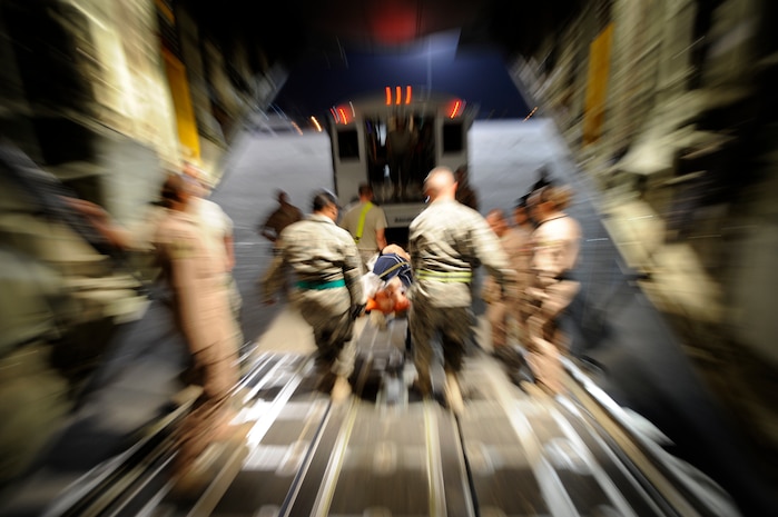 U.S. Air Force Airmen, assigned to the 451st Expeditionary Aeromedical Evacuation Flight, transport patients from a C-130J Super Hercules to an ambulance during an Aeromedical Evacuation mission to transport patients from Camp Bastion to Bagram Air Base July 19, Kandahar Air Field, Afghanistan. (U.S. Air Force Photo by Staff Sgt. Shawn Weismiller)(Released)