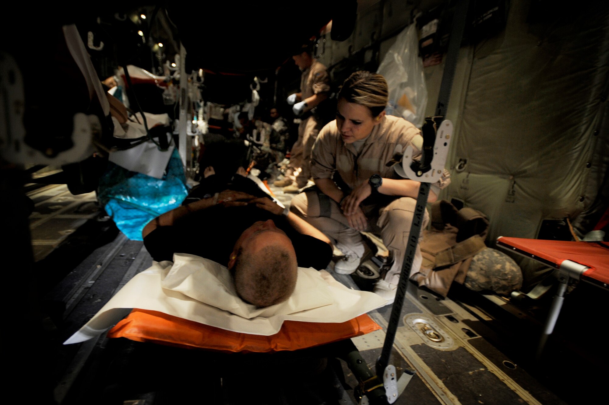 A U.S. Air Force Senior Airman Libby See, 451st Expeditionary Aeromedical Evacuation Flight, aeromedical technician, cares for a patient during an Aeromedical Evacuation mission to transport patients from Camp Bastion to Bagram Air Base July 21, Kandahar Air Field, Afghanistan. (U.S. Air Force Photo by Staff Sgt. Shawn Weismiller)(Released)