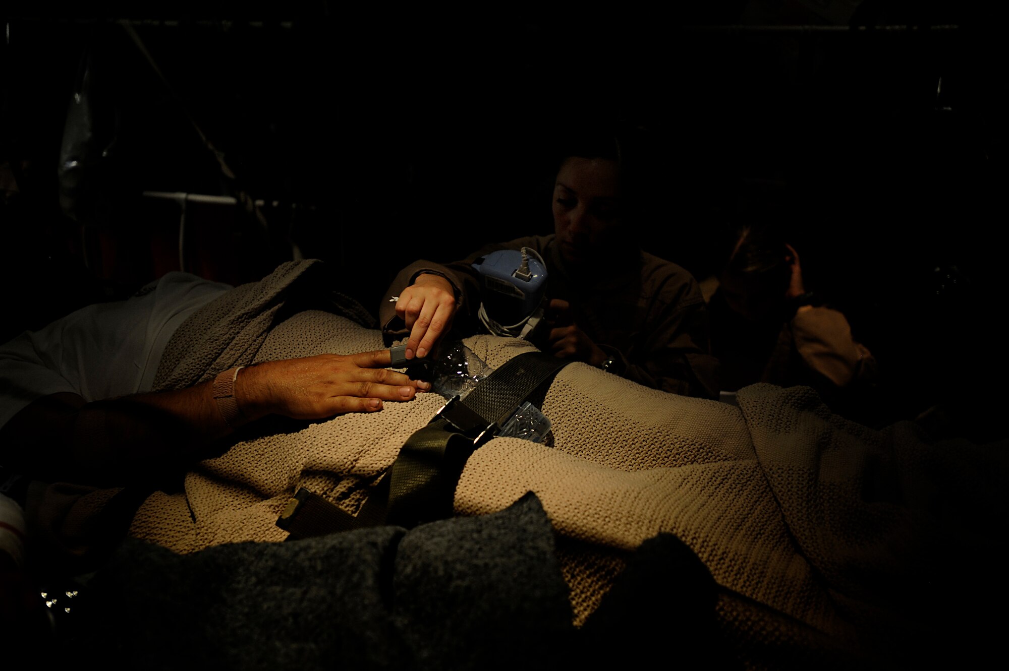 U.S. Air Force Senior Airman Maria Baird , aeromedical technician, 451st Expeditionary Aeromedical Evacuation Flight, monitors the pulse of a patient during an Aeromedical Evacuation mission to transport patients from Kandahar Air Field to Bagram Air Base July 19, Kandahar Air Field, Afghanistan. (U.S. Air Force Photo by Staff Sgt. Shawn Weismiller)(RELEASED)