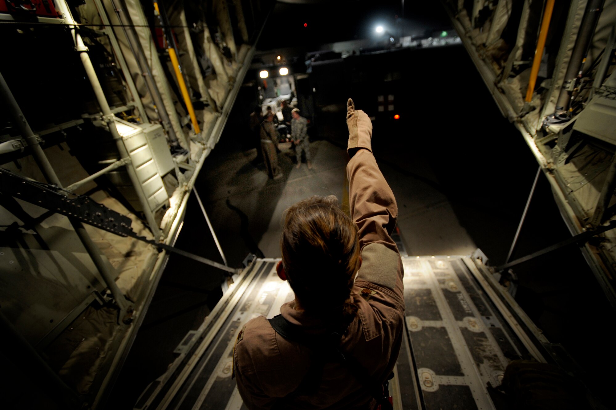 U.S. Air Force Maj. Missy Steckler, flight nurse, 451st Expeditionary Aeromedical Evacuation Flight, directs the transport of patients from an ambulance to the cargo bay of a C-130J Super Hercules July 19, Kandahar Air Field, Afghanistan. (U.S. Air Force Photo by Staff Sgt. Shawn Weismiller/Released)
