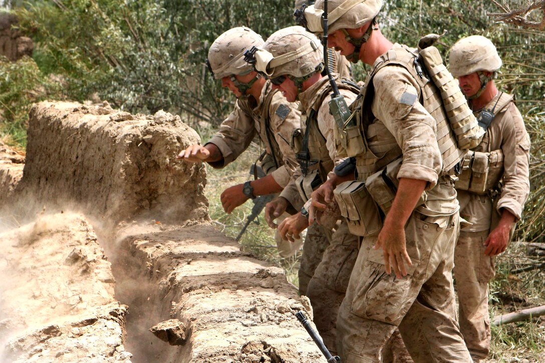 U.S. Marines work together to knock down the Herati wall in Garmsir district in Helmand province, Afghanistan, Aug. 15, 2009. Insurgents have used the compound for cover and concealment during several firefights with Marines in recent weeks. The Marines are assigned to Echo Company, 2nd Battalion, 8th Marine Regiment.