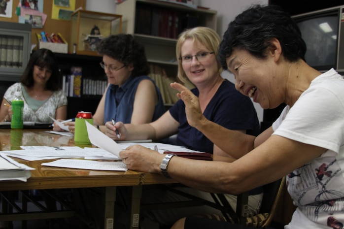 Yoko Mikami, the class instructor, shows her students a hand gesture they can use to politely deny a wrong order at a restaurant during the Japanese Survival Class in the Japanese American Society’s office here Aug. 20. To maintain a relaxed atmosphere, Mikami sits around the table with her students and allows them to talk and ask questions freely making it less like a class.