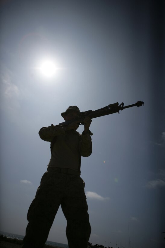 A Marine practices room-clearing techniques with his squad members before he and the other Marines of Company G conduct a mechanized night raid here Aug. 20. The raid was the final exercise Battalion Landing Team 2/4 will hold before deploying with the 11th Marine Expeditionary Unit.