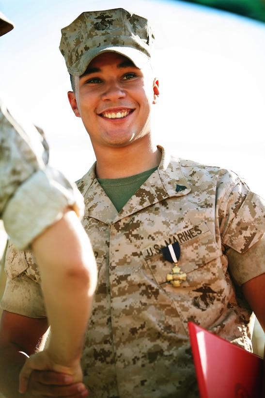 Cpl. Richard S. Weinmaster, a Squad Automatic Weapon gunner with 3rd Platoon, Company E, 2nd Battalion, 7th Marine Regiment, smiles as he is congratulated by a Marine after a ceremony where he was awarded the Navy Cross Medal for valor and received a meritorious promotion to corporal at Lance Cpl. Torrey L. Gray Field Thursday.