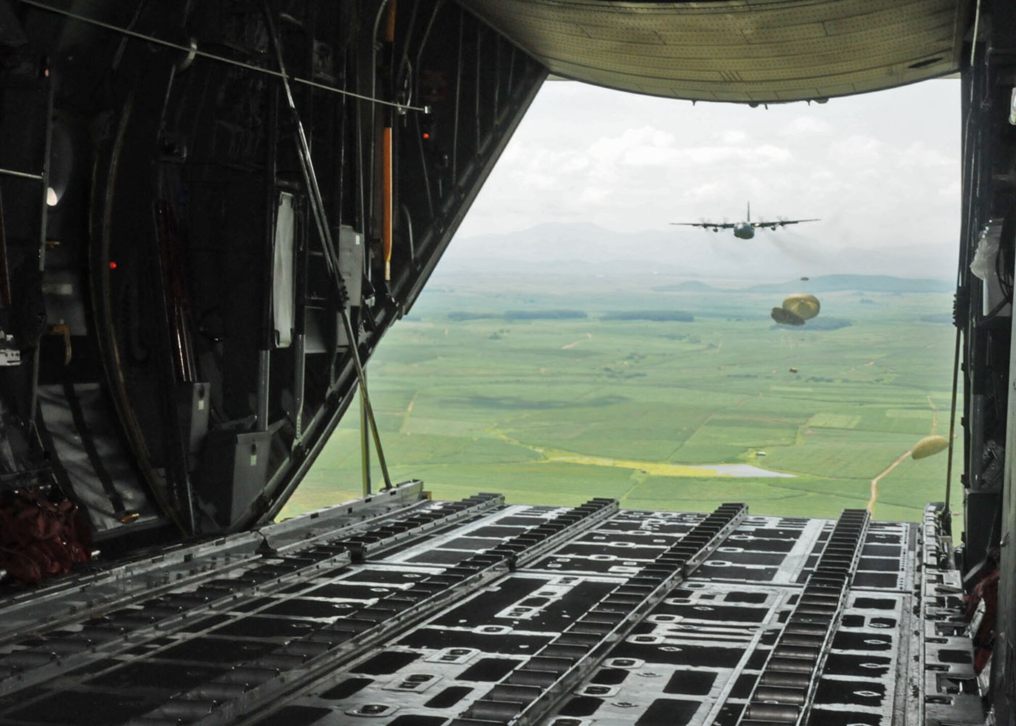 SUBANG ROYAL MALAYSIAN AIR FORCE BASE, Malaysia -- Aircrews from the 36th Airlift Squadron at Yokota Air Base, Japan, pefrom a heavy-equipment airdrop from two C-130 Hercules Aug. 19 during the 2009 Pacific Airlift Rally here. The PAR is a biennial exercise involving Pacific Rim nations which enhances military airlift interoperability with a focus in humanitarian assistance and disaster relief operations. The exercise consists of a tabletop exercise and a field-training exercise involving three C-130 aircraft from the 374th Airlift Wing at Yokota Air Base, Japan, and one C-130 each from the Royal Malaysian Air Force, Royal Australian Air Force, Republic of Singapore Air Force and Royal New Zealand Air Force. (U.S. Air Force photo/Staff Sgt. Veronica Pierce)