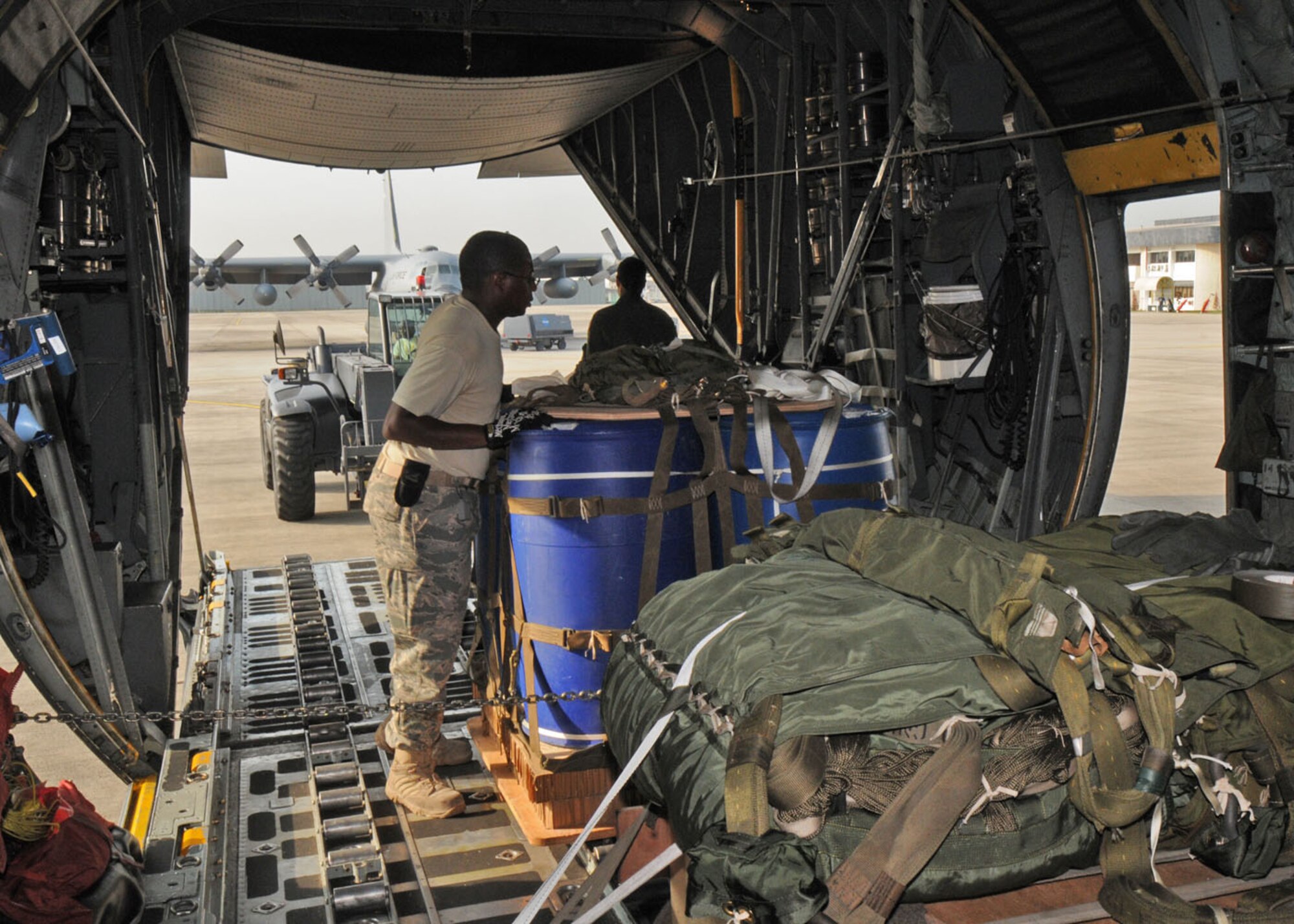 SUBANG ROYAL MALAYSIAN AIR FORCE BASE, Malaysia -- Senior Airman Warren Smith, 374th Logistics Readiness Squadron combat mobility flight technician, loads cargo onto a C-130 Hercules from the 36th Airlift Squadron at Yokota Air Base, Japan, for a heavy-equipment airdrop Aug. 19 during the 2009 Pacific Airlift Rally here. The PAR is a biennial exercise involving Pacific Rim nations which enhances military airlift interoperability with a focus in humanitarian assistance and disaster relief operations. The exercise consists of a tabletop exercise and a field-training exercise involving three C-130 aircraft from the 374th Airlift Wing at Yokota Air Base, Japan, and one C-130 each from the Royal Malaysian Air Force, Royal Australian Air Force, Republic of Singapore Air Force and Royal New Zealand Air Force. (U.S. Air Force photo/Staff Sgt. Veronica Pierce)