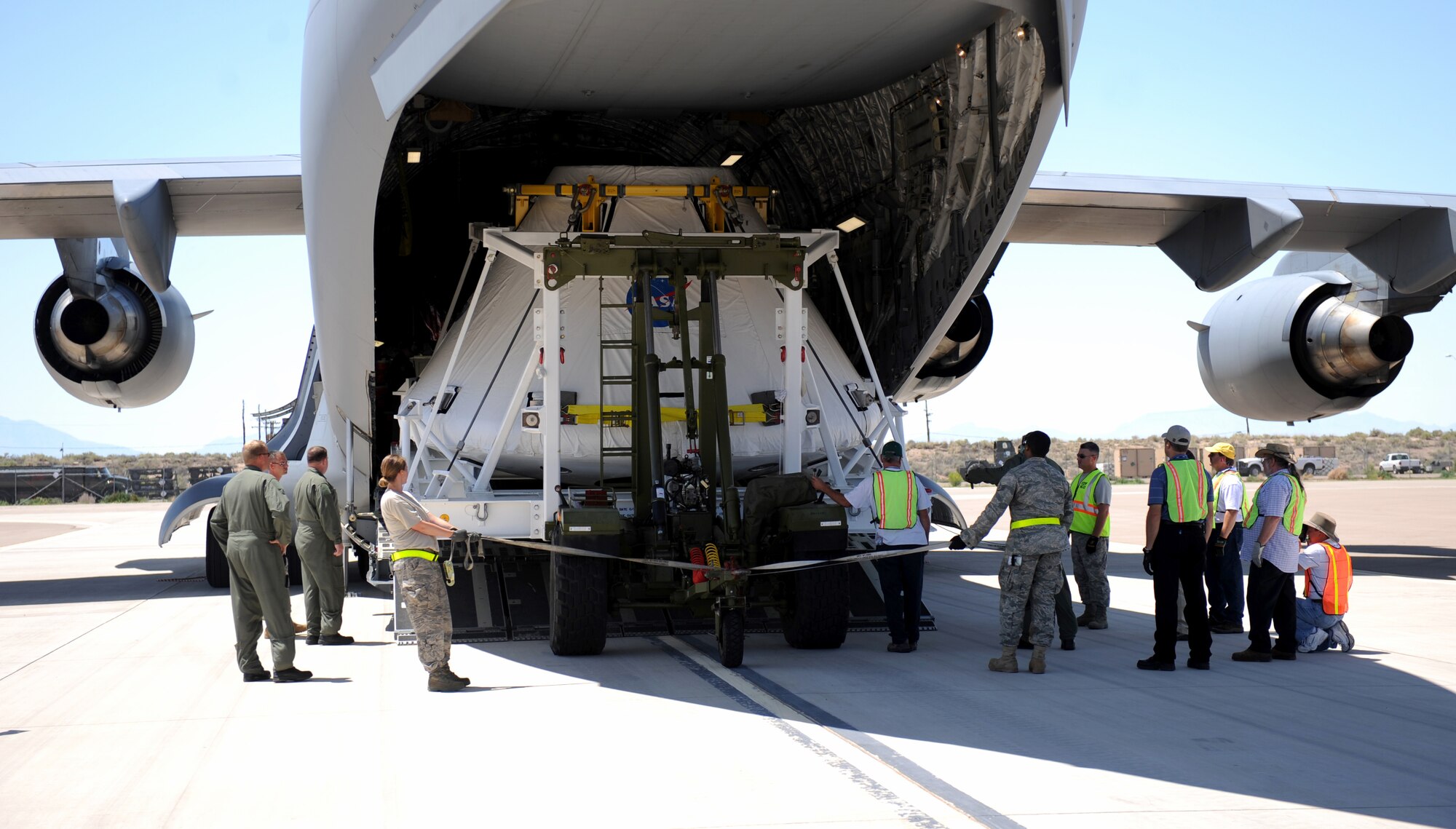 HOLLOMAN AIR FORCE BASE, N.M. -- Airmen from the 49th Logistics Readiness Squadron here help unload NASA's Pad Abort One Crew Module from a Mississippi Air National Guard C-17 at BEAR Base Aug. 19. The module arrived here from Dryden Flight Research Center, Edwards, Calif., so it could be transported by tractor-trailer to White Sands Missile Range to test its ability to get away from the launch pad in the event of an emergency. Billed as the shuttle replacement program for NASA, the Orion Program is designed to take the next generation of astronauts to space. (U.S. Air Force photo by Senior Airman Michael Means)